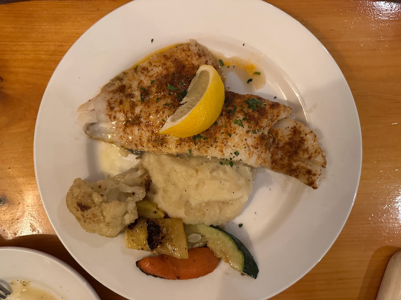 Fish, potatoes, and vegetables on place. 