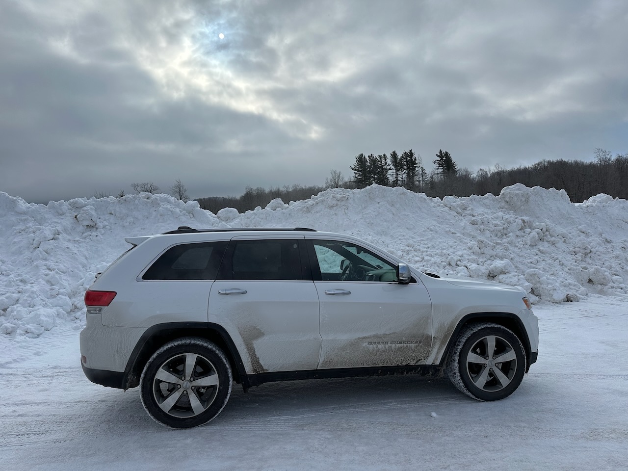 2014 Jeep Grand Cherokee parked in front of snowbank. 