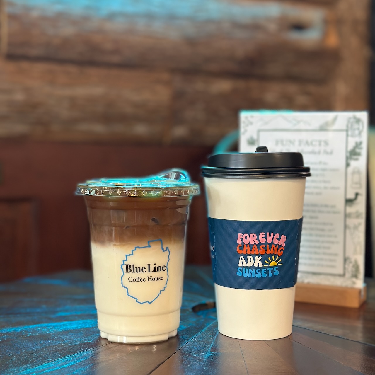 Hot coffee and iced latte on wooden table. 