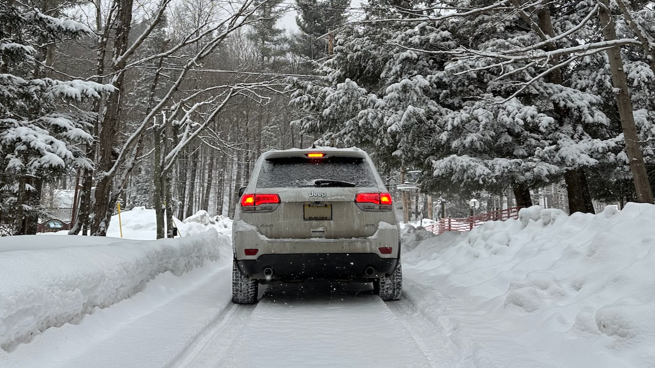 Rear view of 2014 Jeep Grand Cherokee on snow-covered road. 