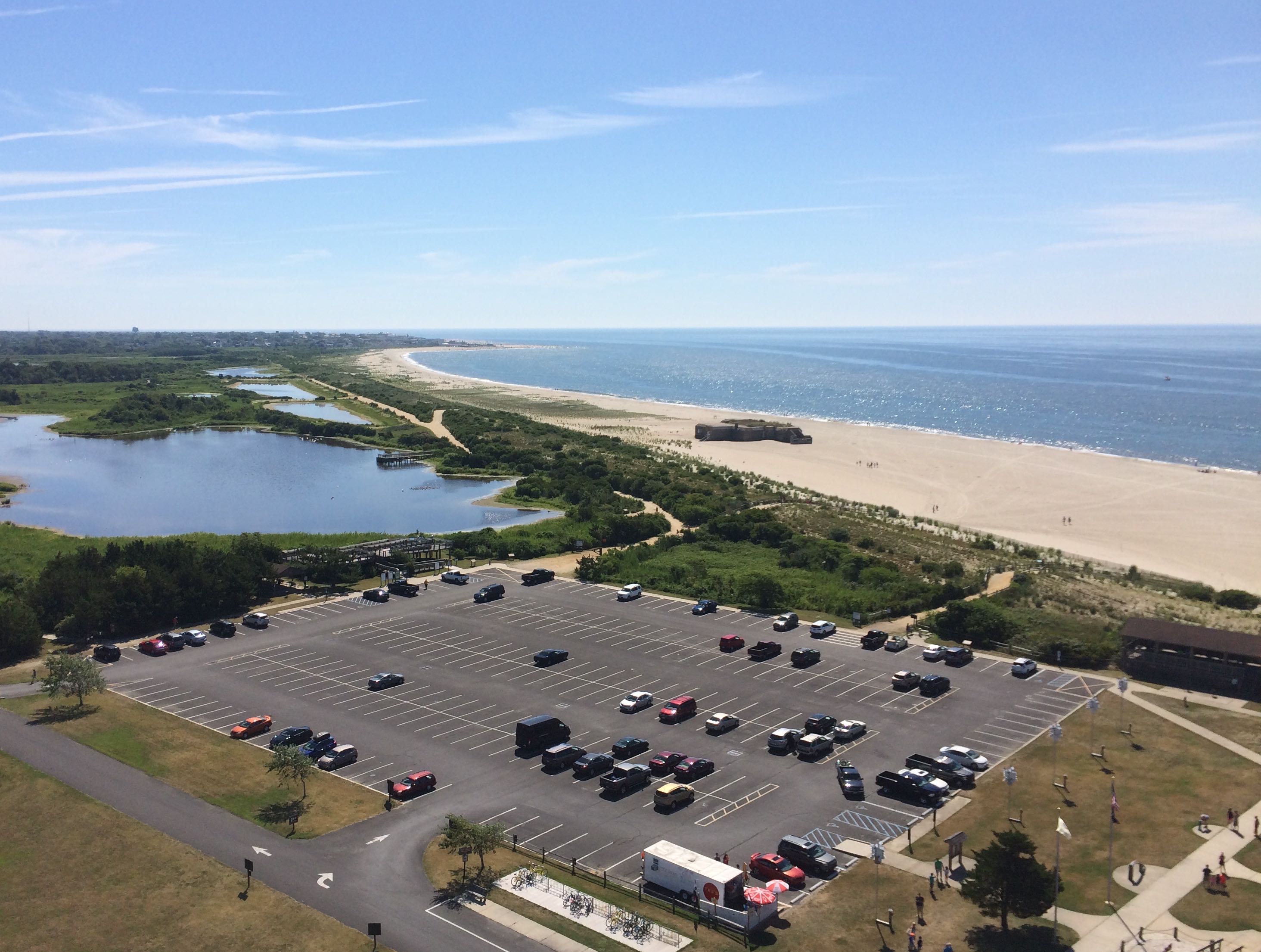 View of beach and ocean from atop lighthouse. 
