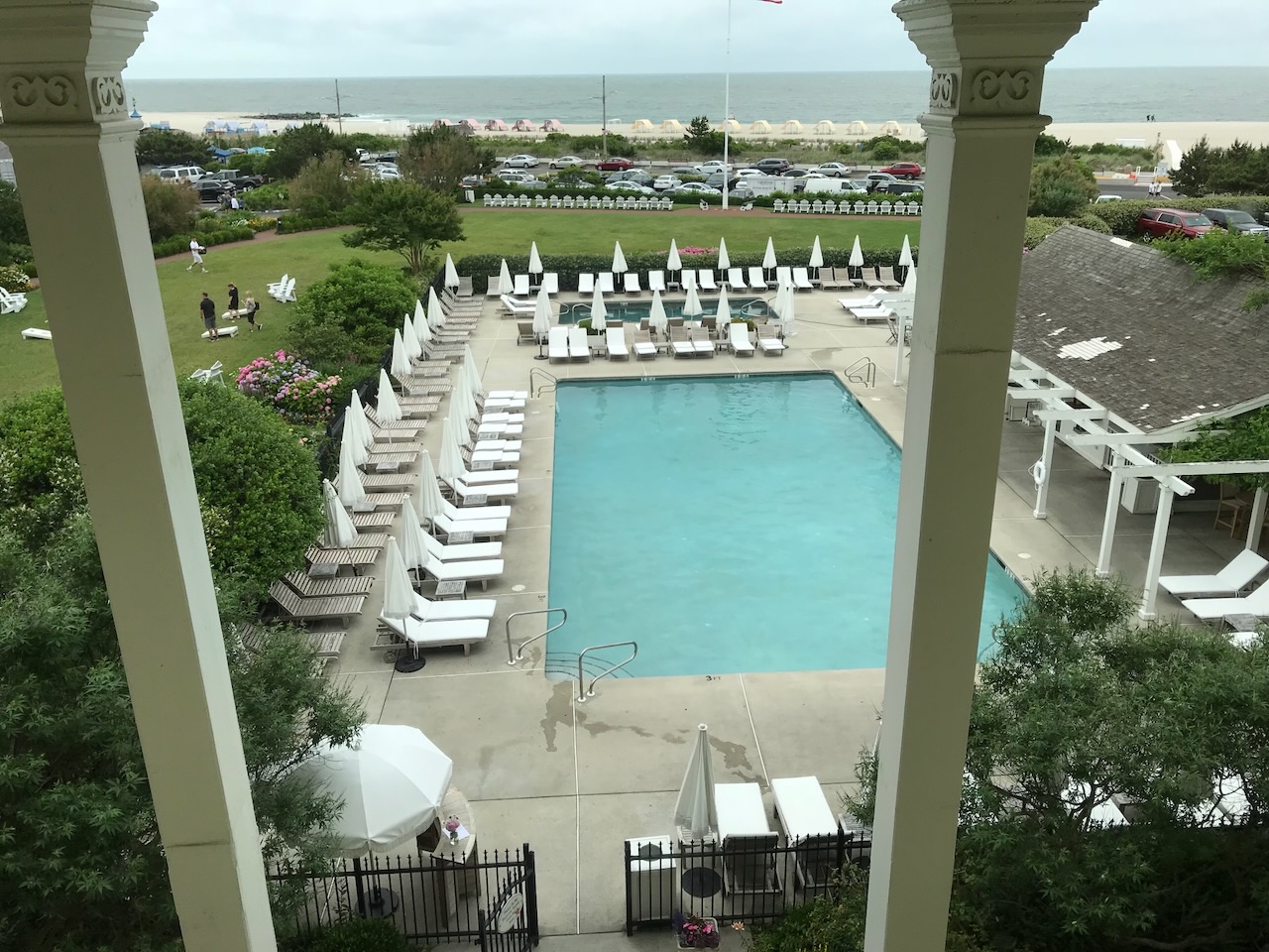 View of pool and ocean through window of hotel. 