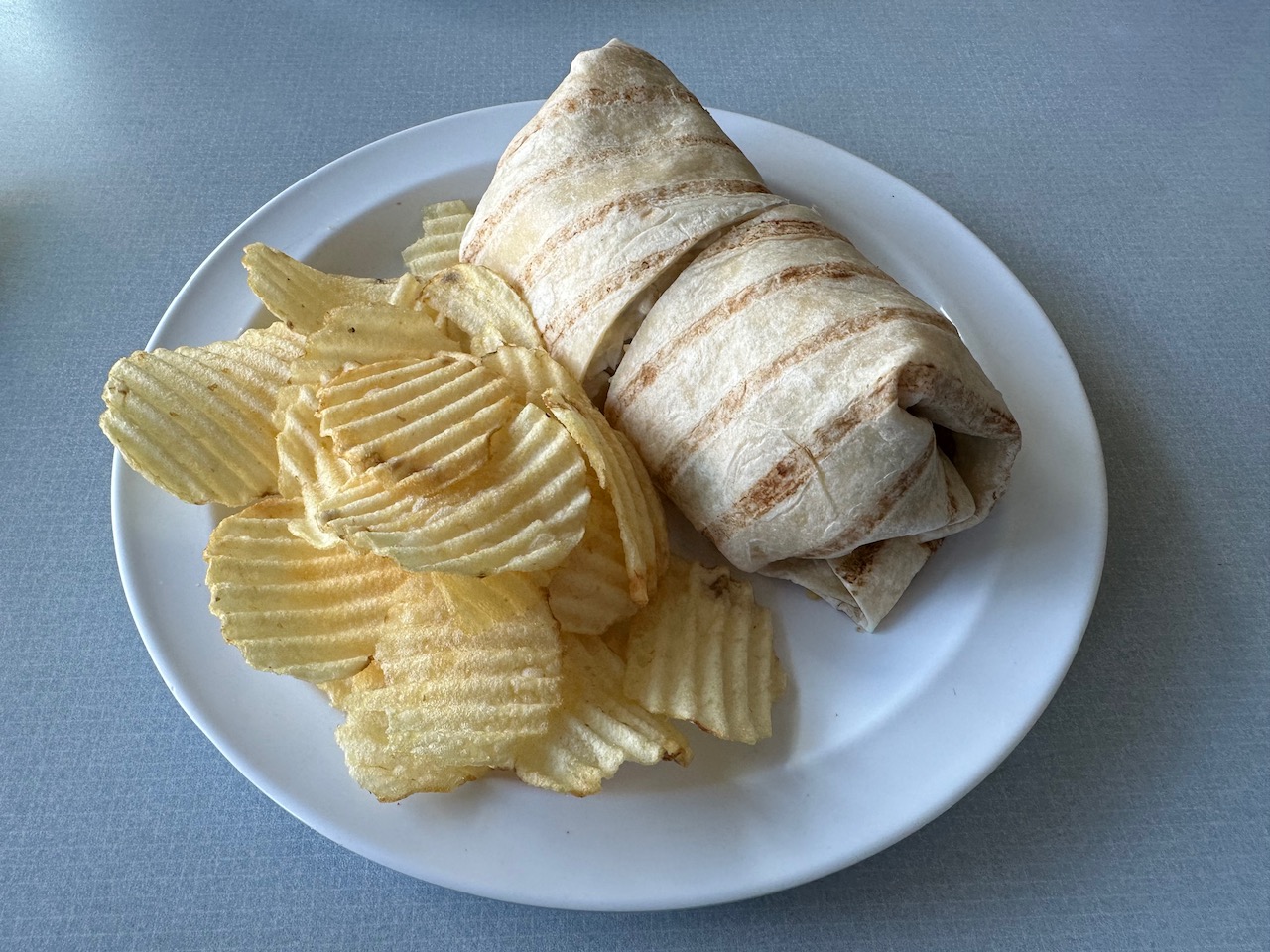 Wrap and chips on white plate. 