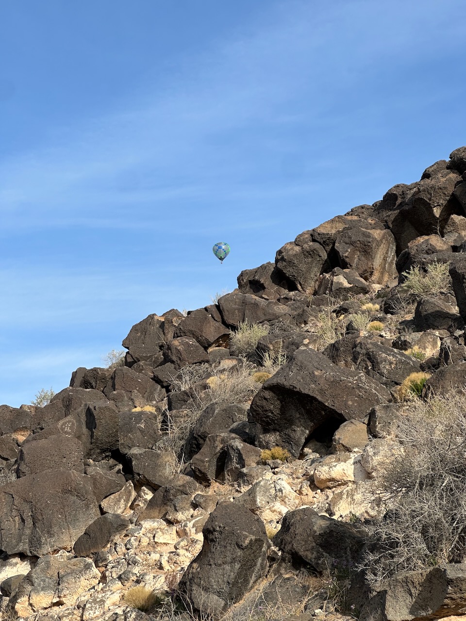 Hot air balloon in sky over rock formation. 
