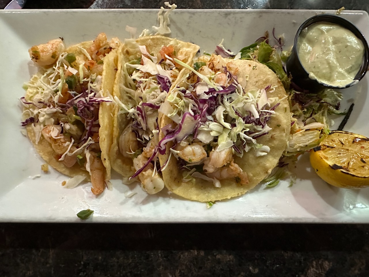 Plate with shrimp tacos and slaw on side. 