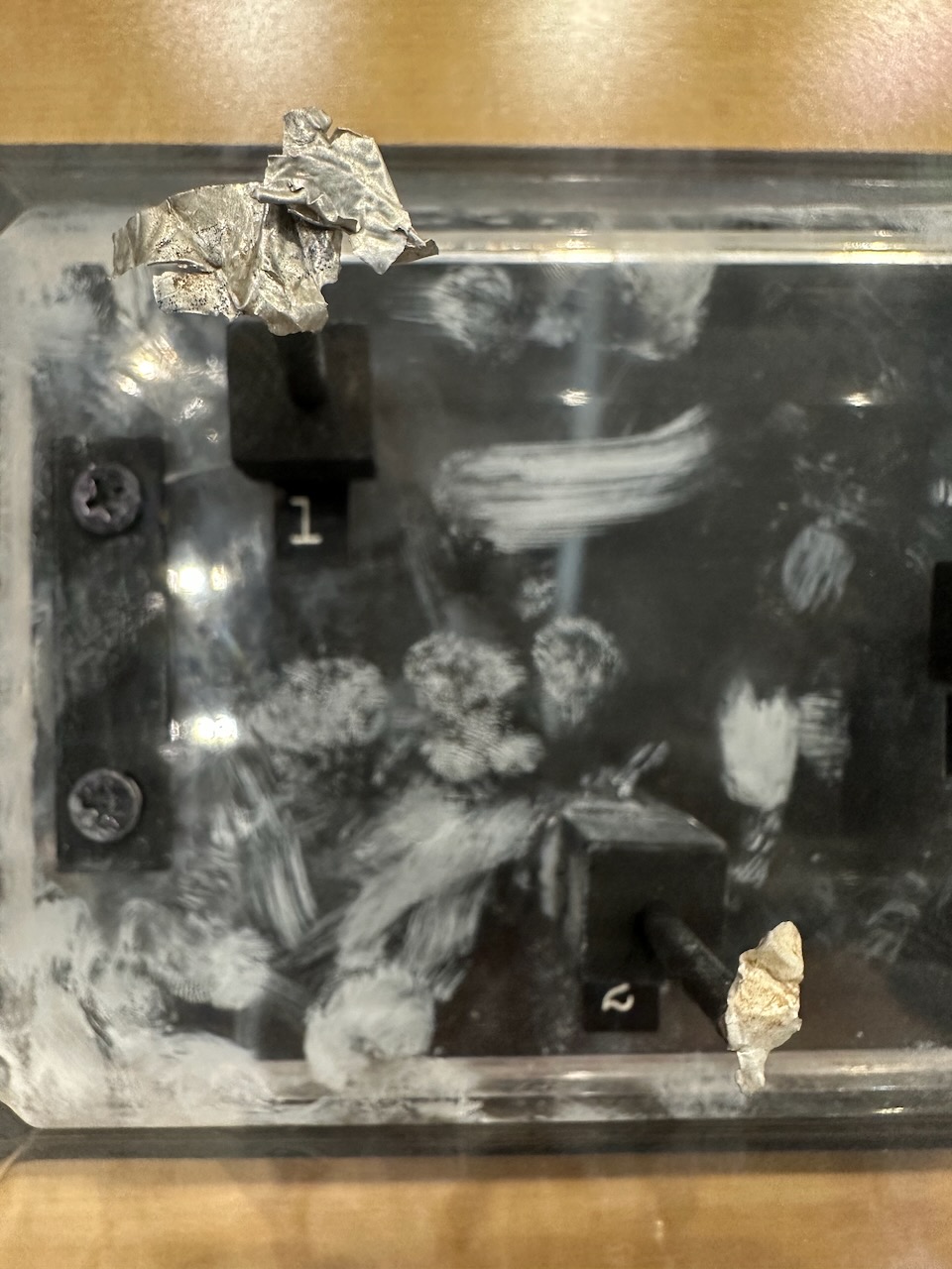 Debris from Roswell crash on display stand in glass case. 