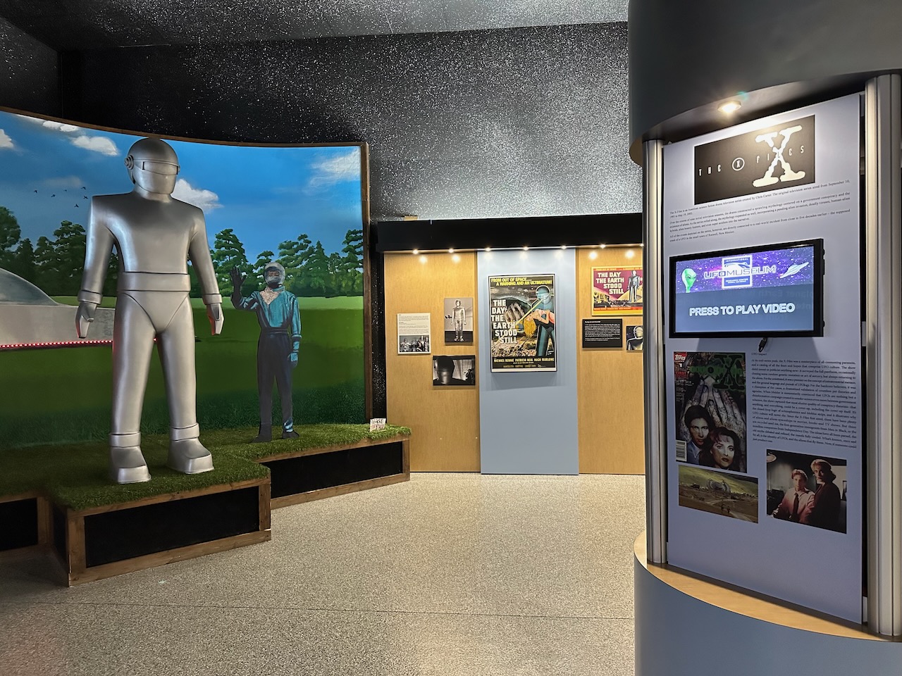 Exhibit on modern media representation of aliens including The Day the Earth Stood Still and The X-Files. 