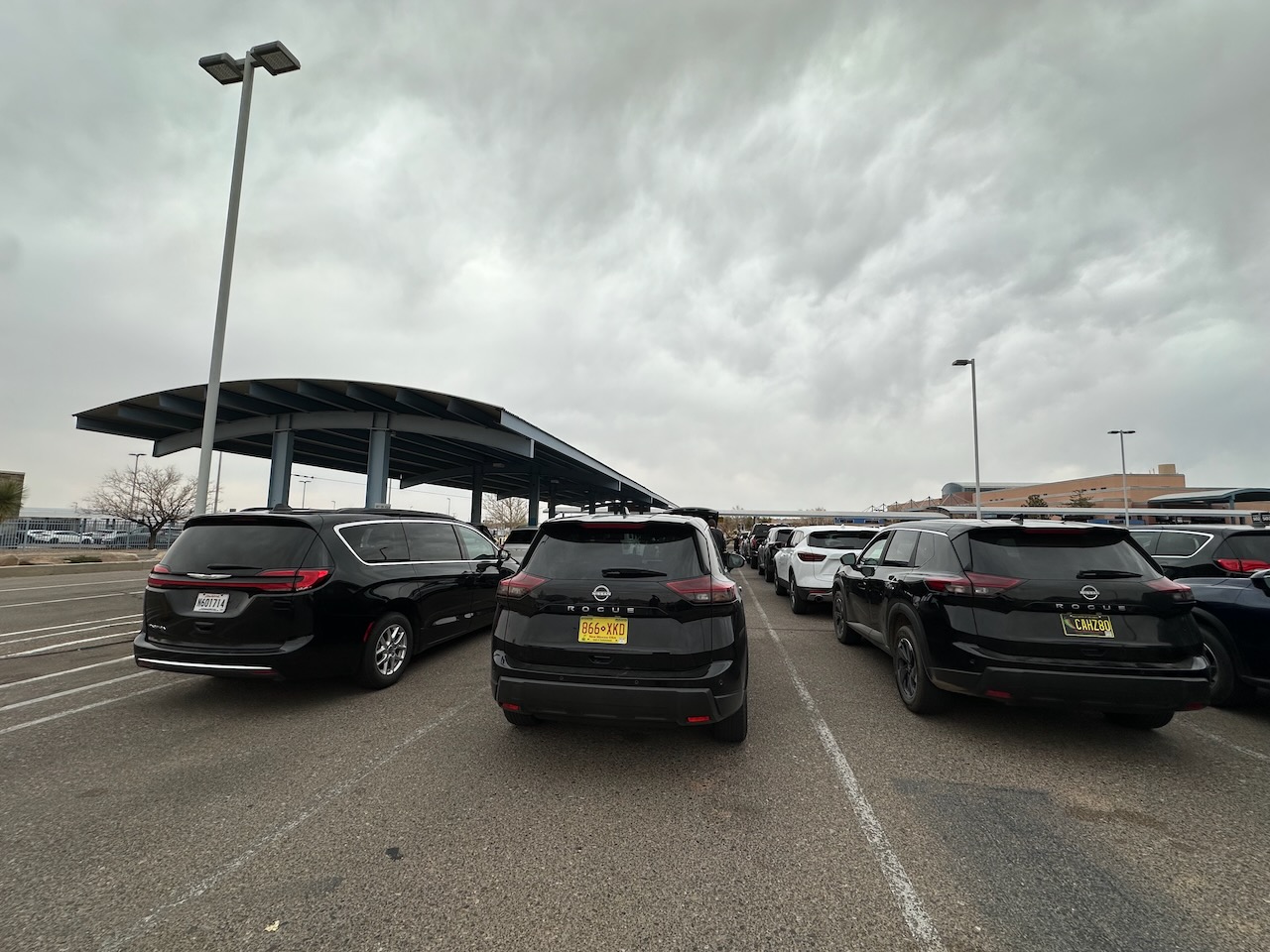 Cars at Hertz Rental Car return lot, including Nissan Rogue. 