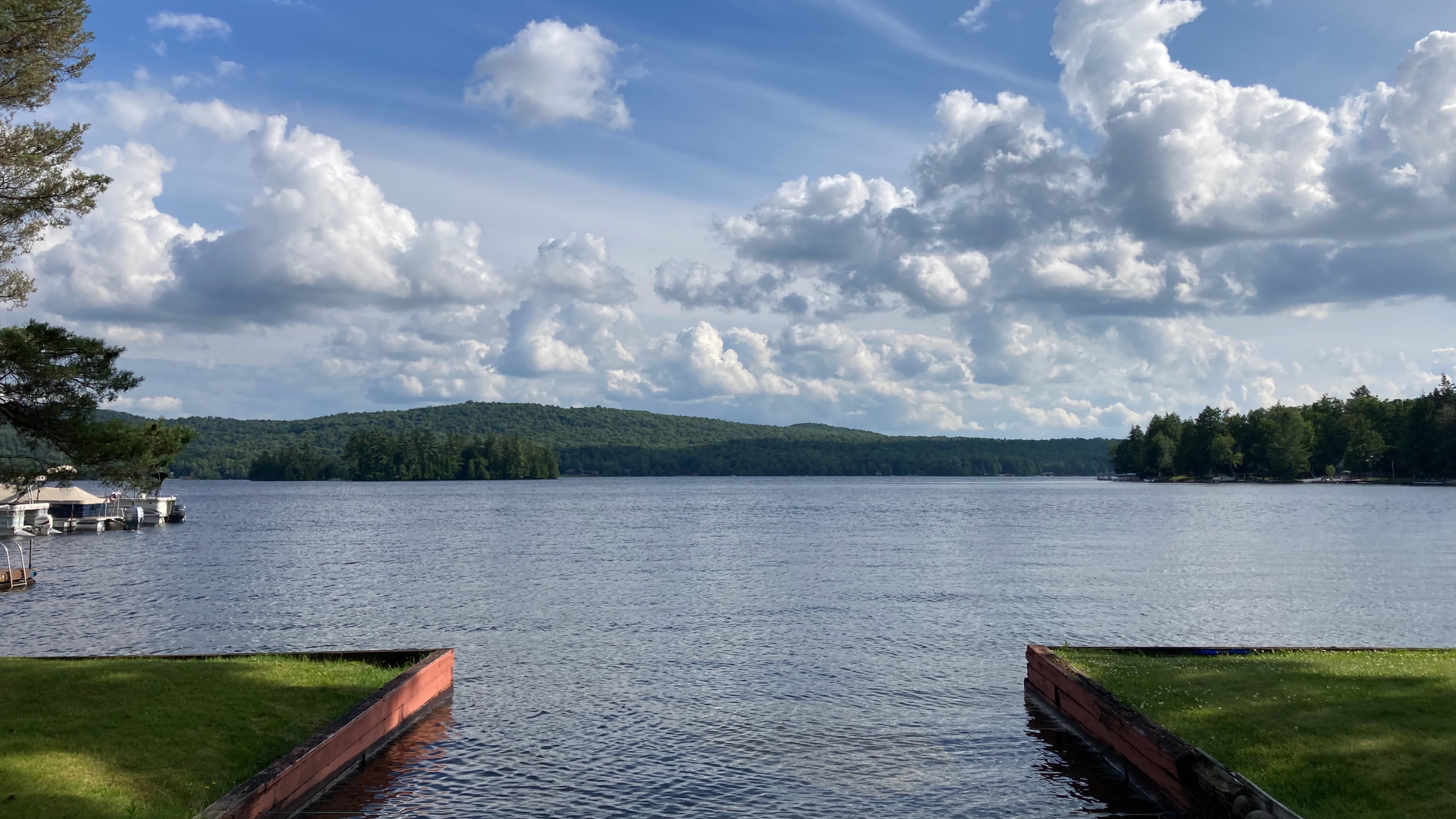 View of Fourth Lake from shore, with mountains in distance. 