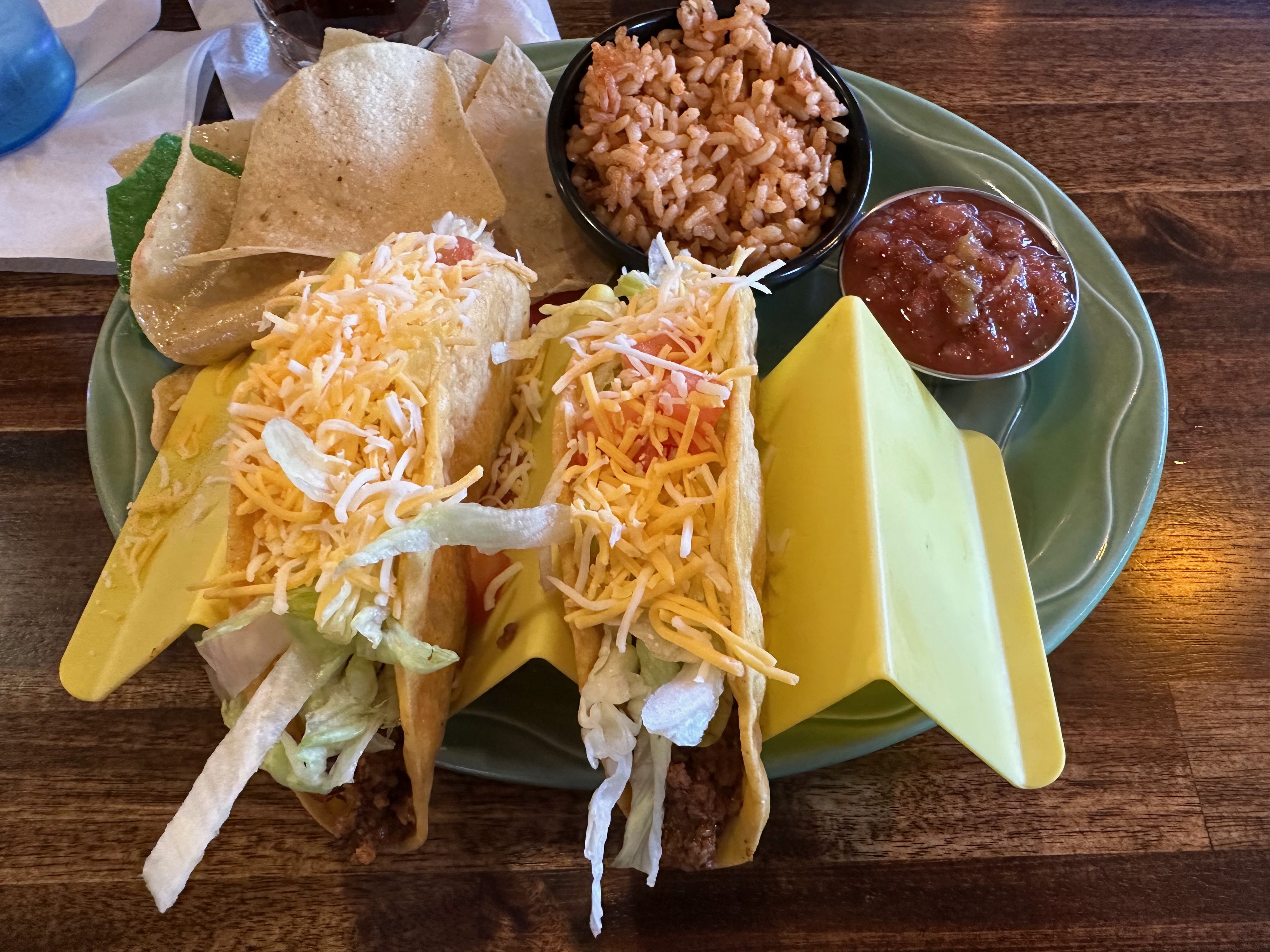 Two tacos, rice, and beans on plate.