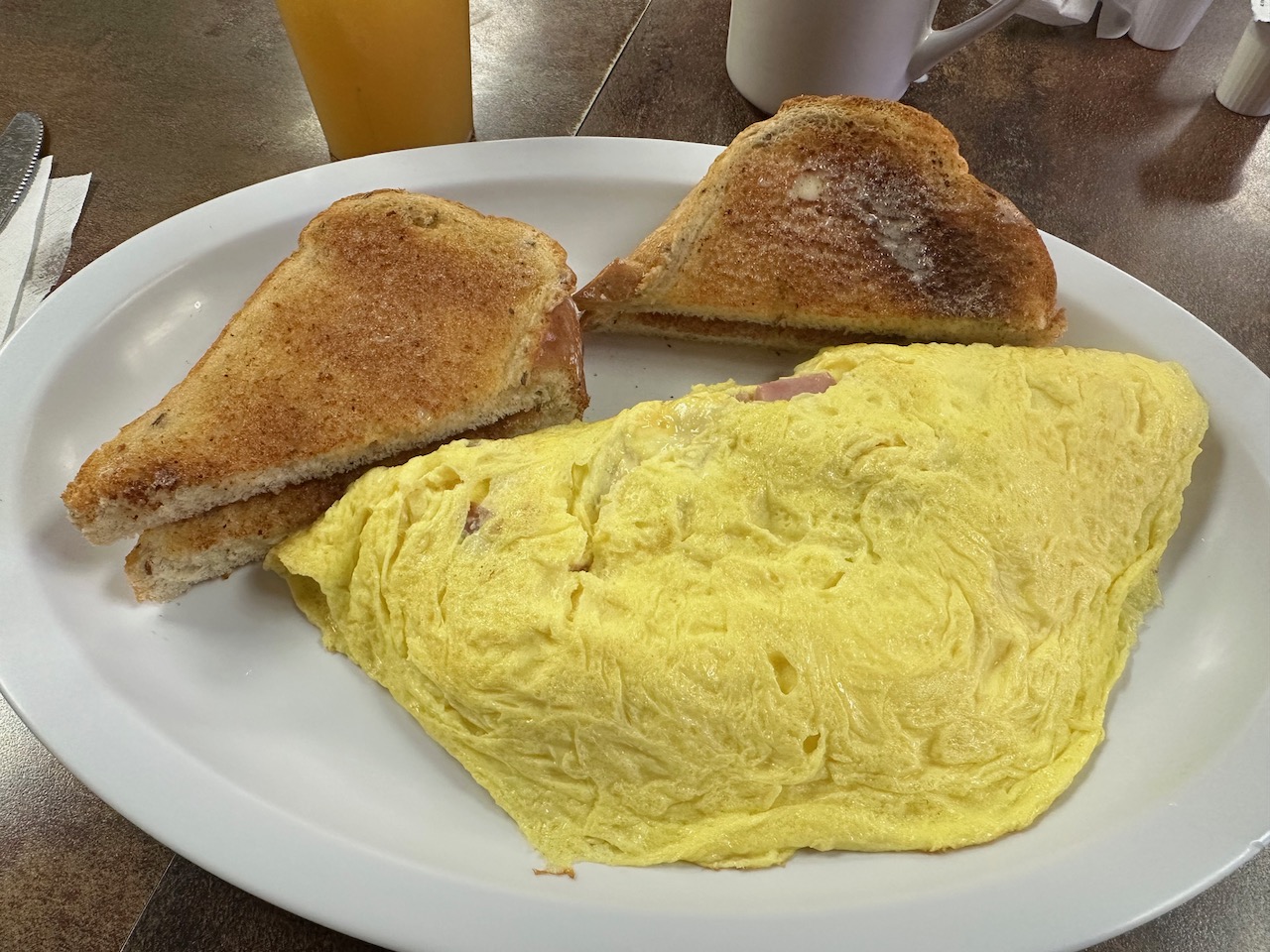 Omelette and toast on white plate. 