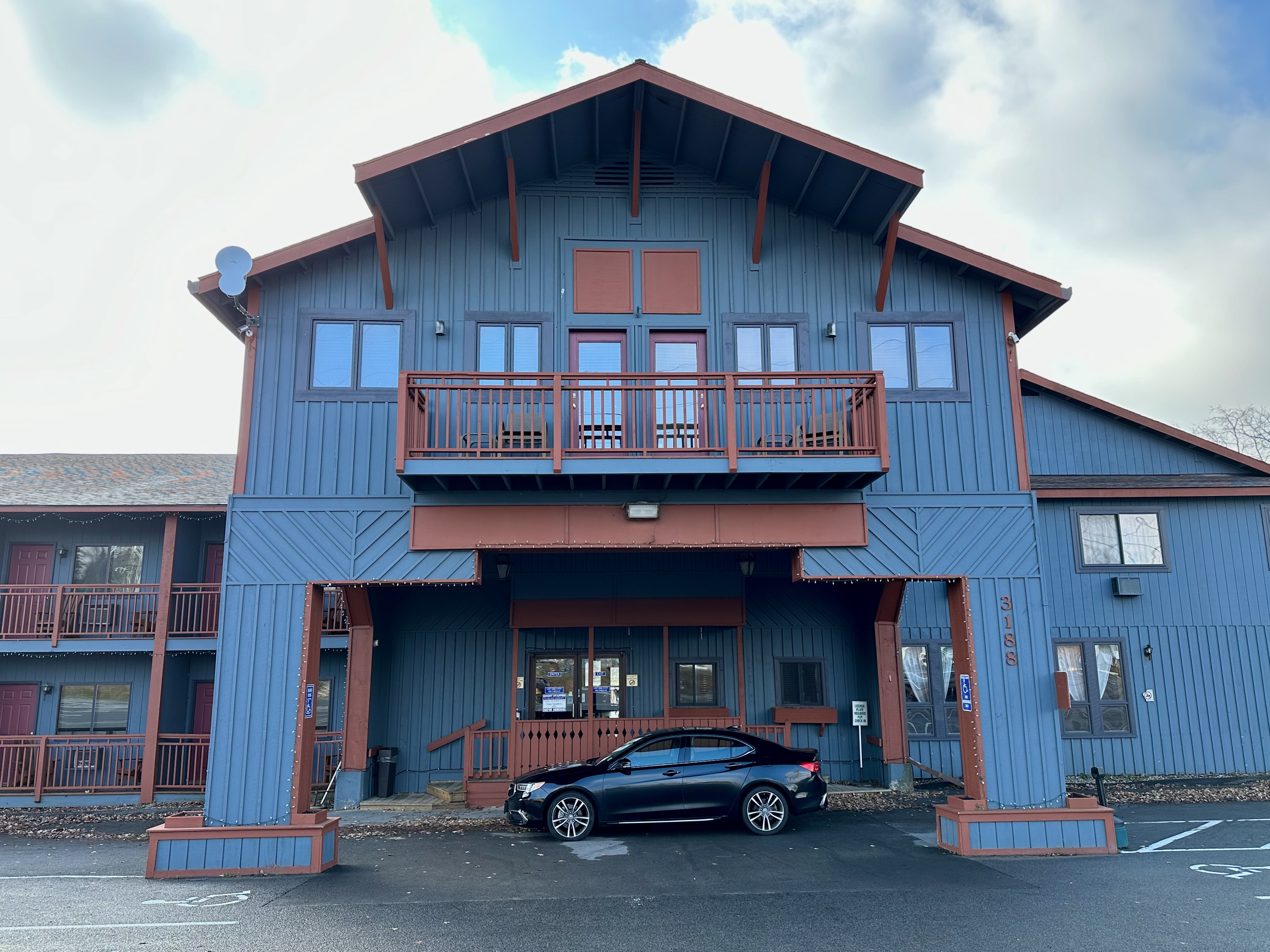 Exterior of Waters Edge Inn with 2020 Acura TLX parked in front of it. 