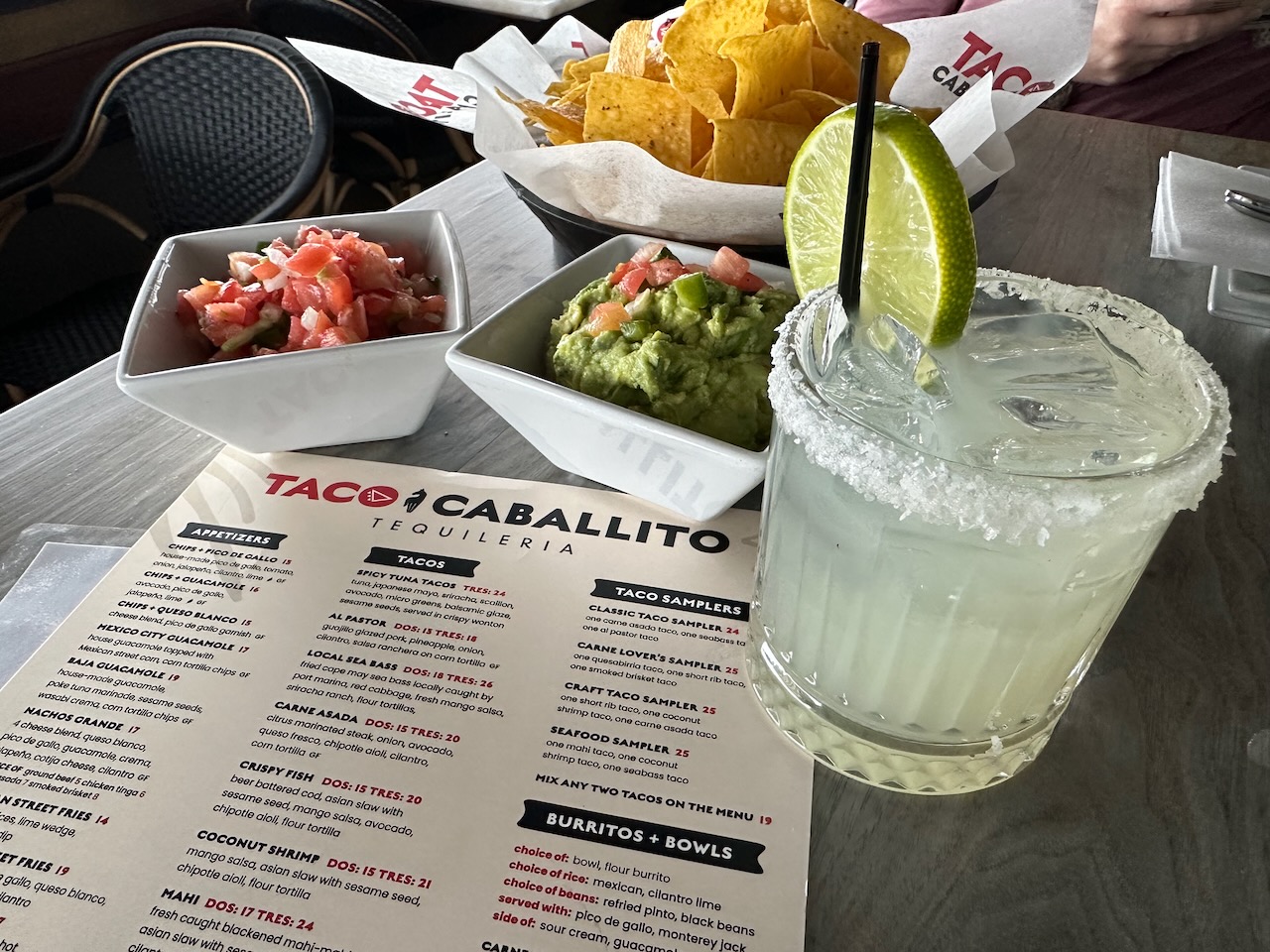 Margarita, menu, chips, and salsa on table. 