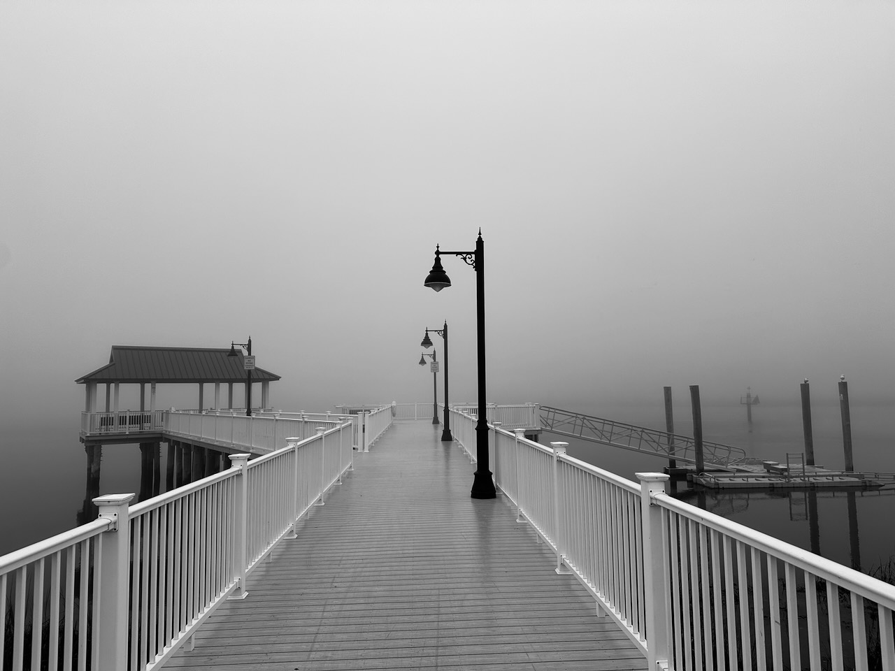 View of fishing pier with thick fog behind it. 