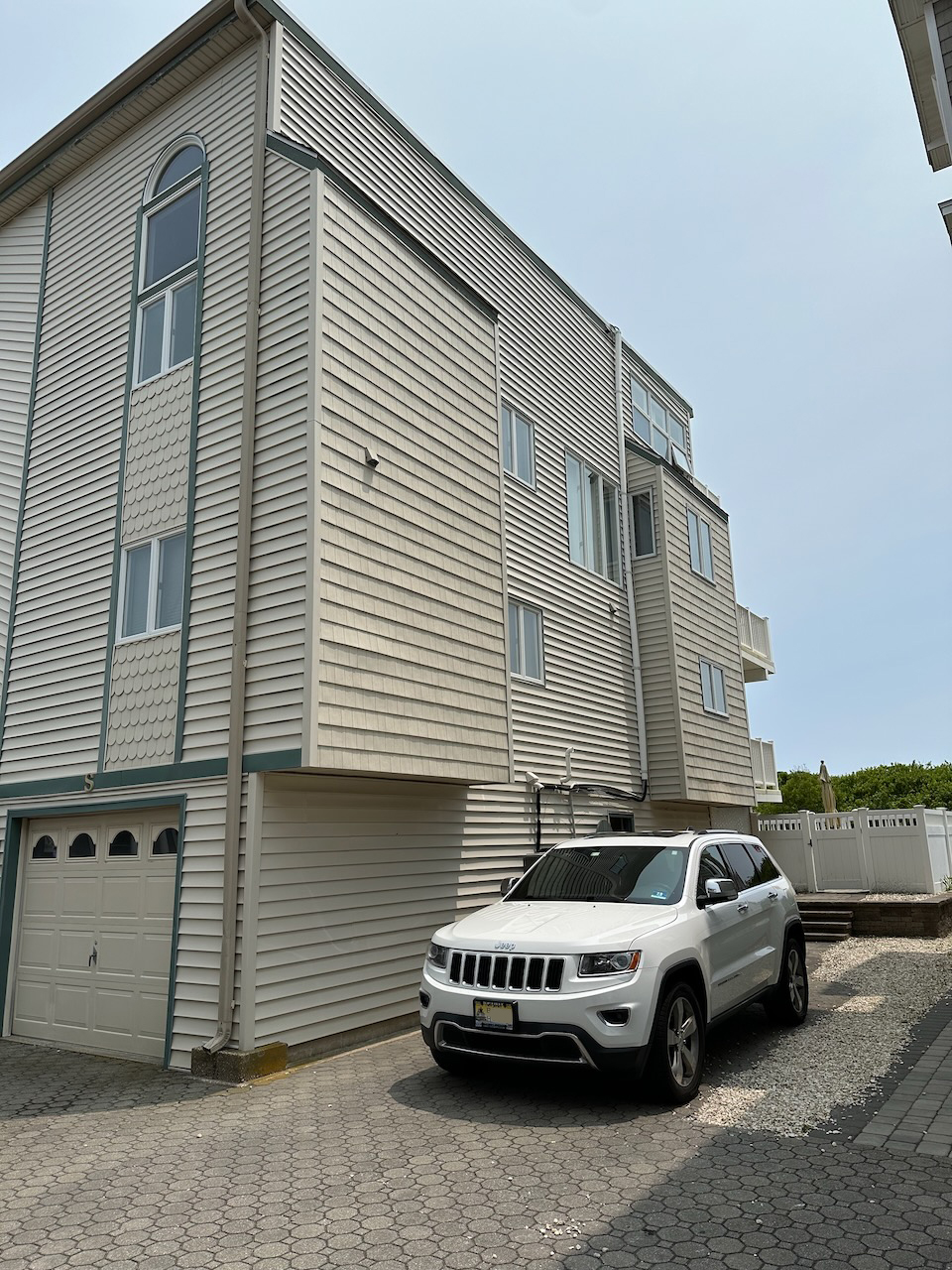 2014 Jeep Grand Cherokee parked beside duplex house at the beach. 