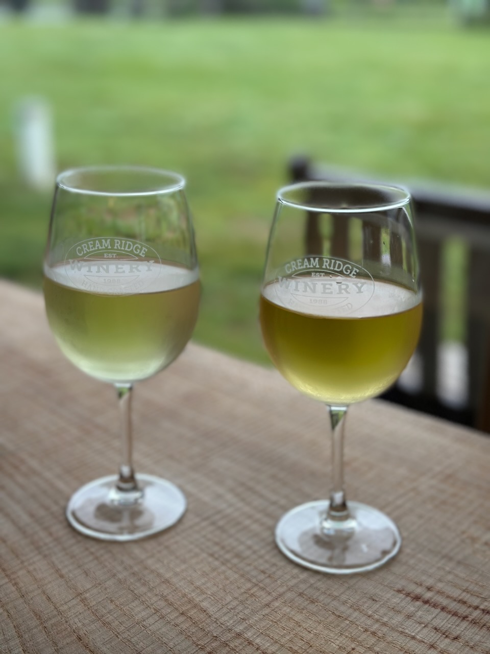 Two glasses on white wine on table.