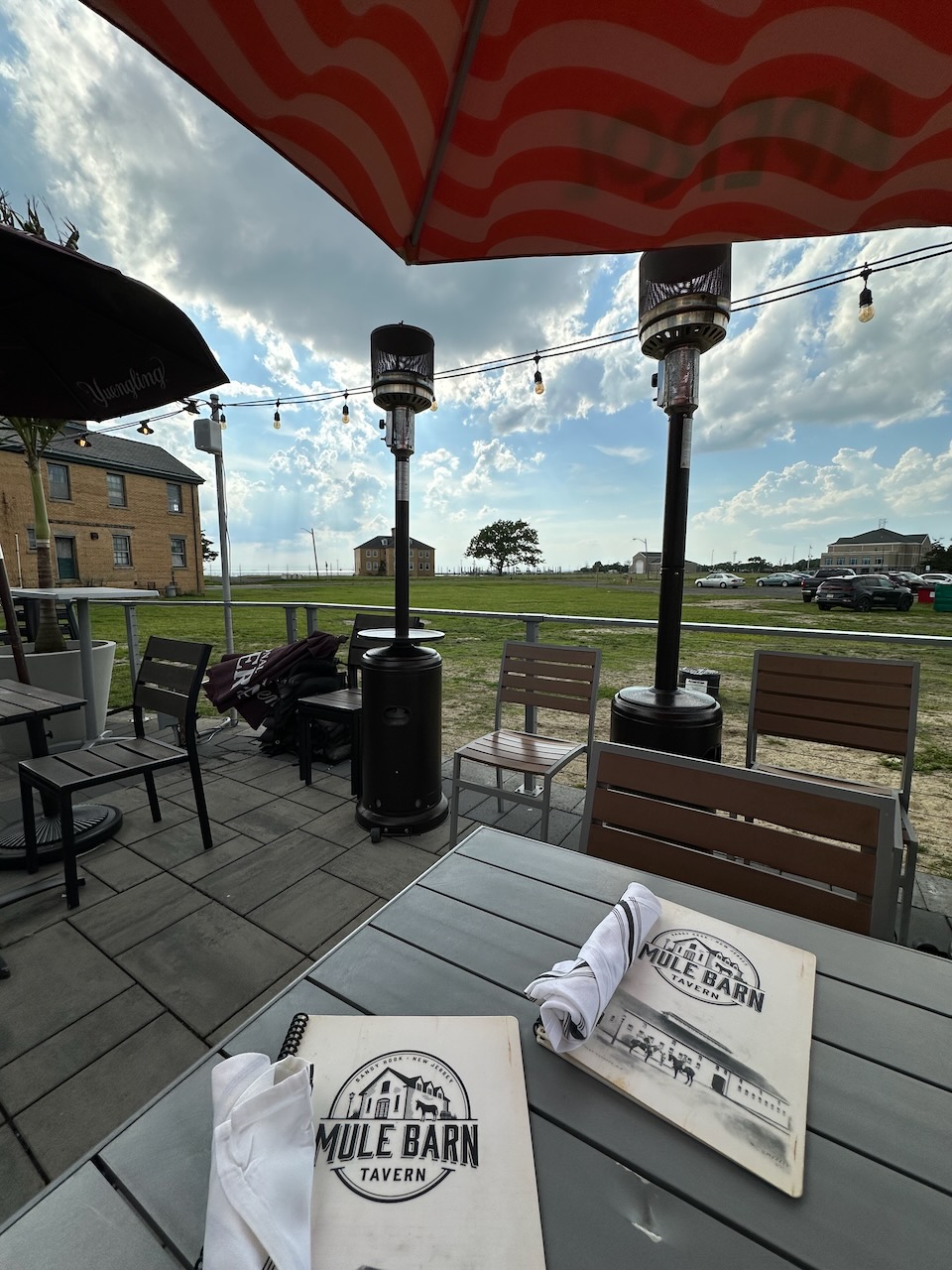 Patio table with umbrella outside of the Mule Barn Tavern. Menus are on the table. 