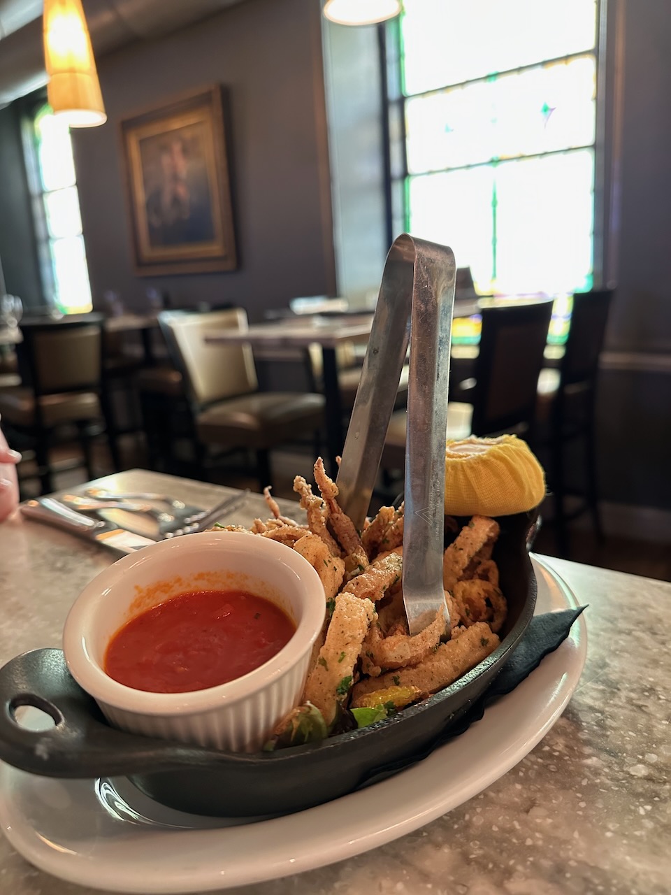 Calamari in skillet, served on white platter. 