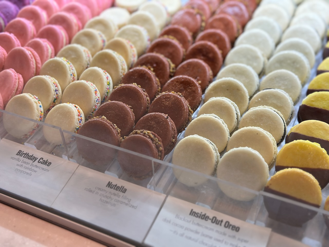 Macaroons on display behind glass case. 