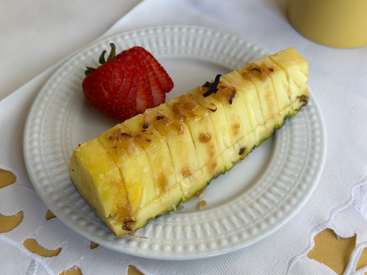 Grilled pineapple slice on white plate.