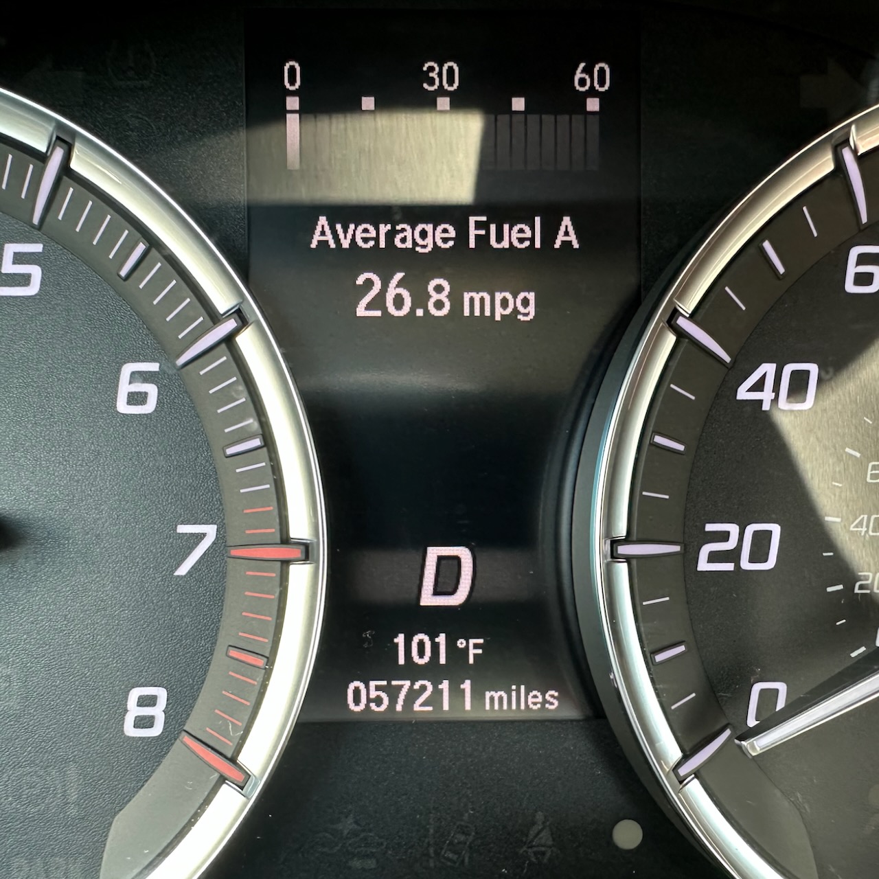 Car odoemter reading 57211 miles and car thermometer reading 101 degrees. 