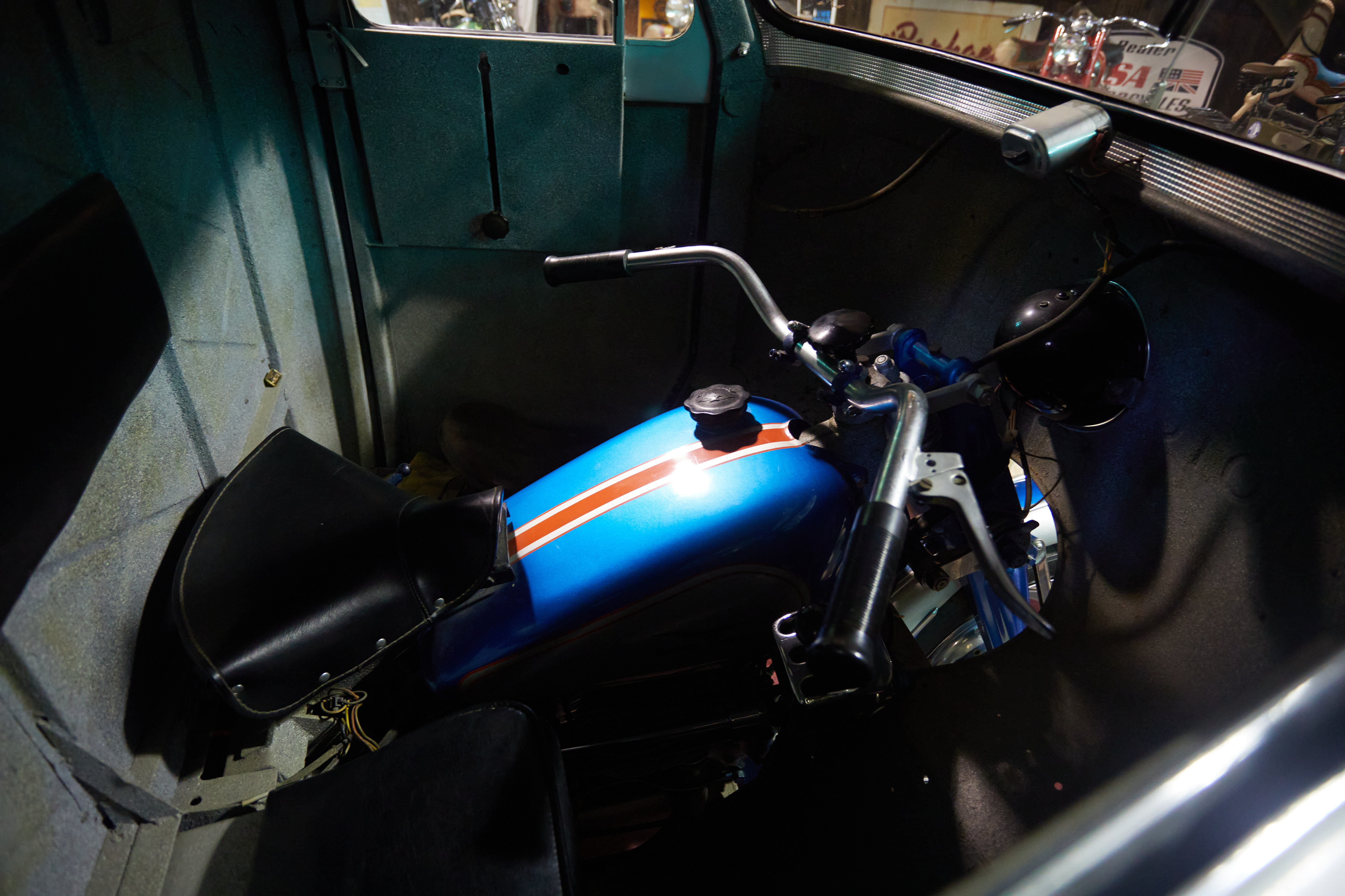 Motorcycle within front cab of Moto Guzzi dump truck.