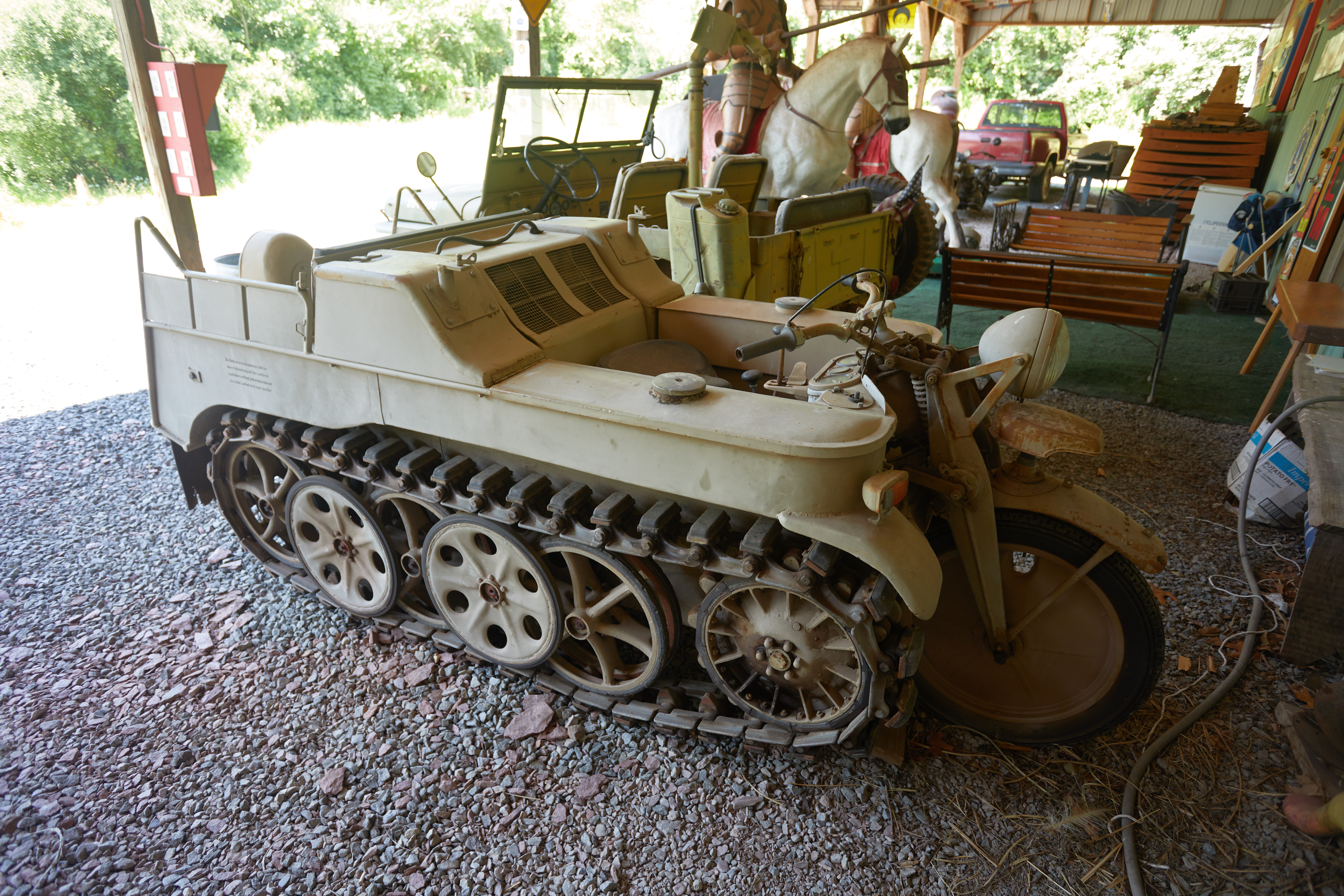 Kettenkrad tracked motorcycle under lean-to pavilion.