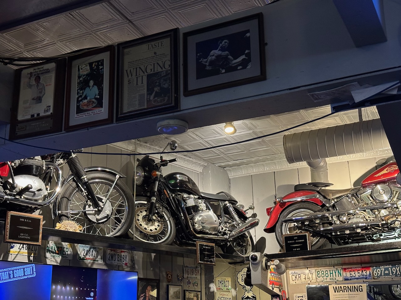 View of bar, with motorcycles mounted on racks at top of walls.