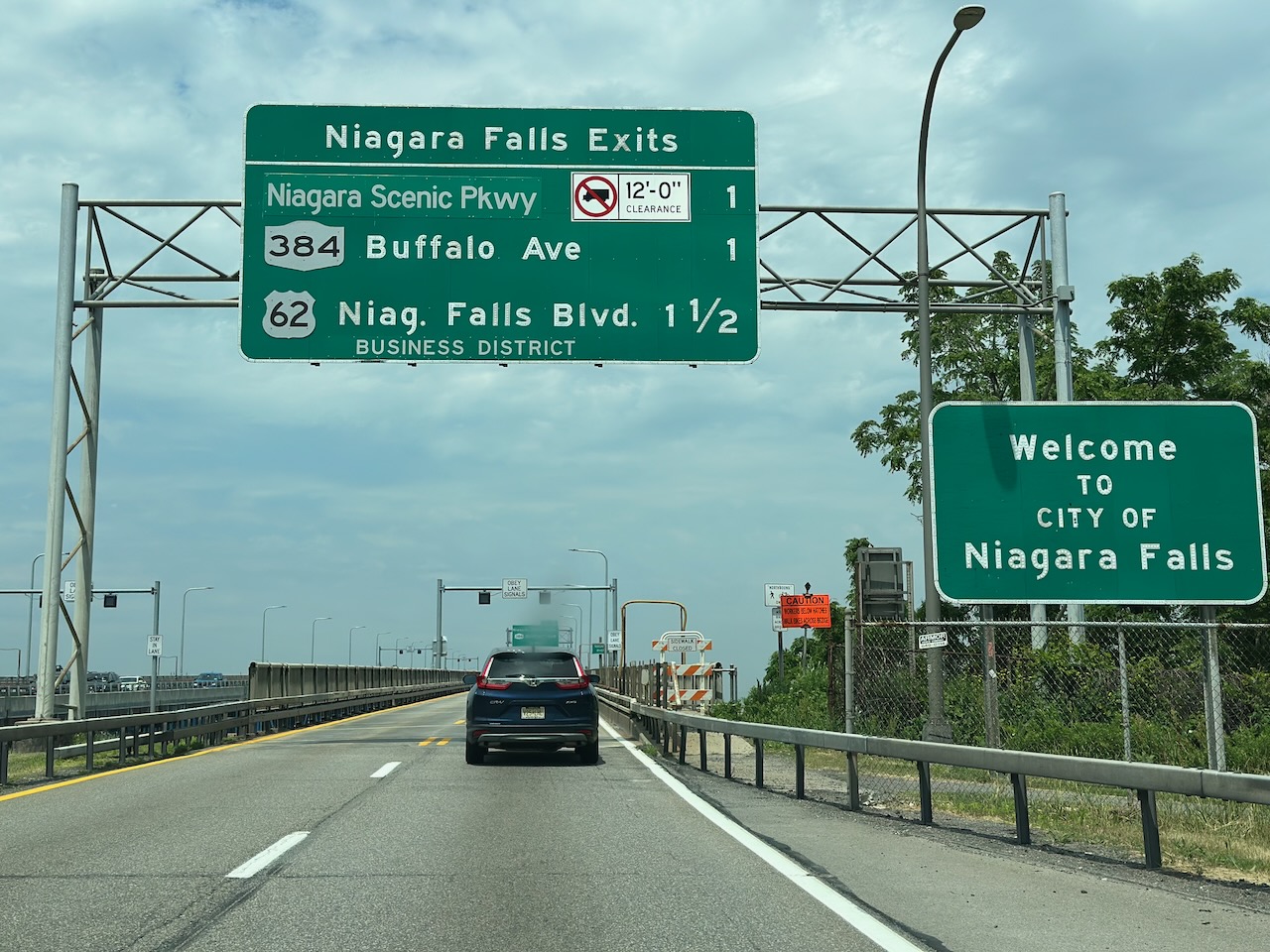 Sign above highway with exits for Niagara Falls. 