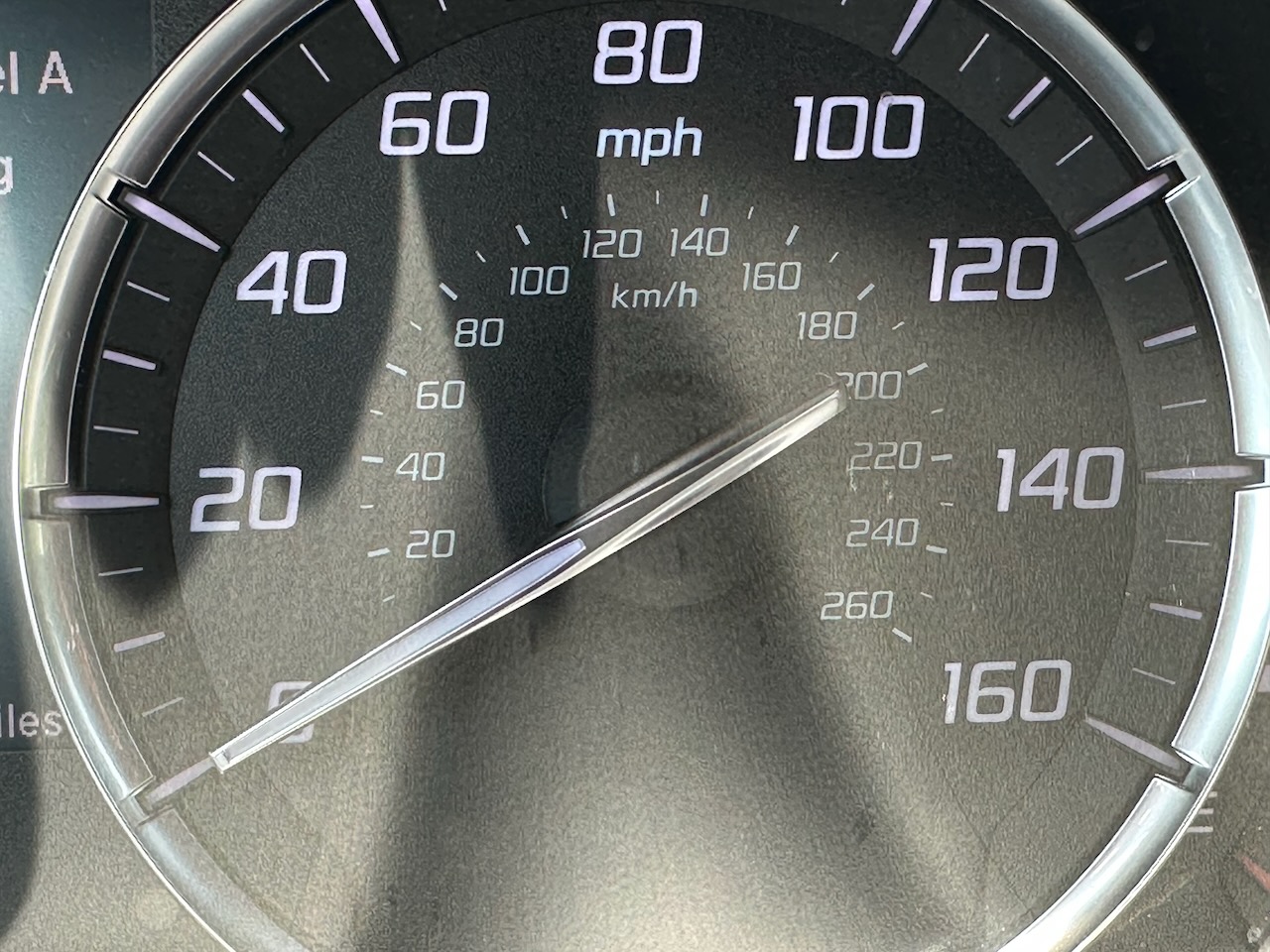 Car speedometer with numbers for miles per hour and smaller inner ring with kilometers per hour. 