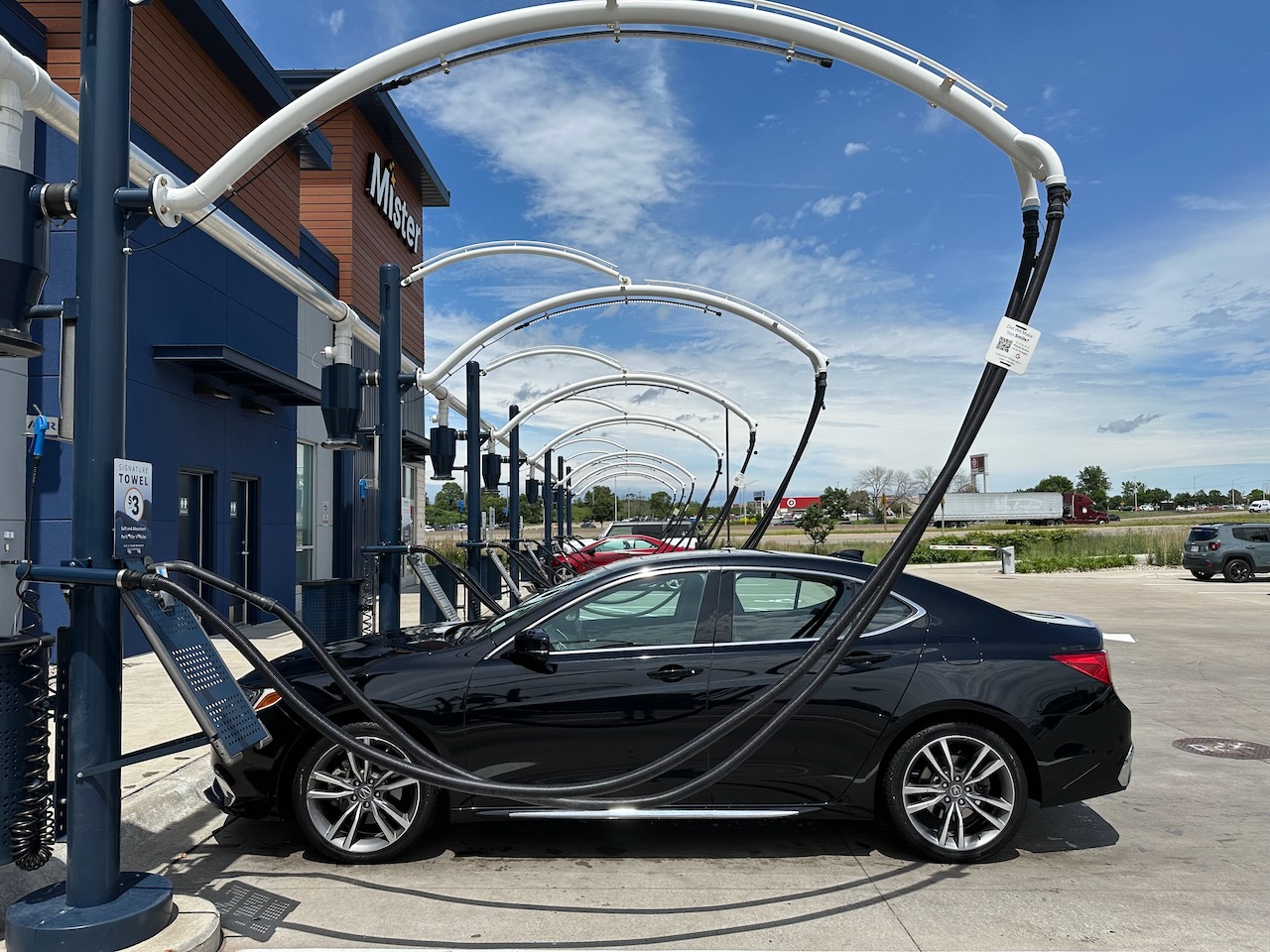 Acura TLX parked by vacuums at car wash.