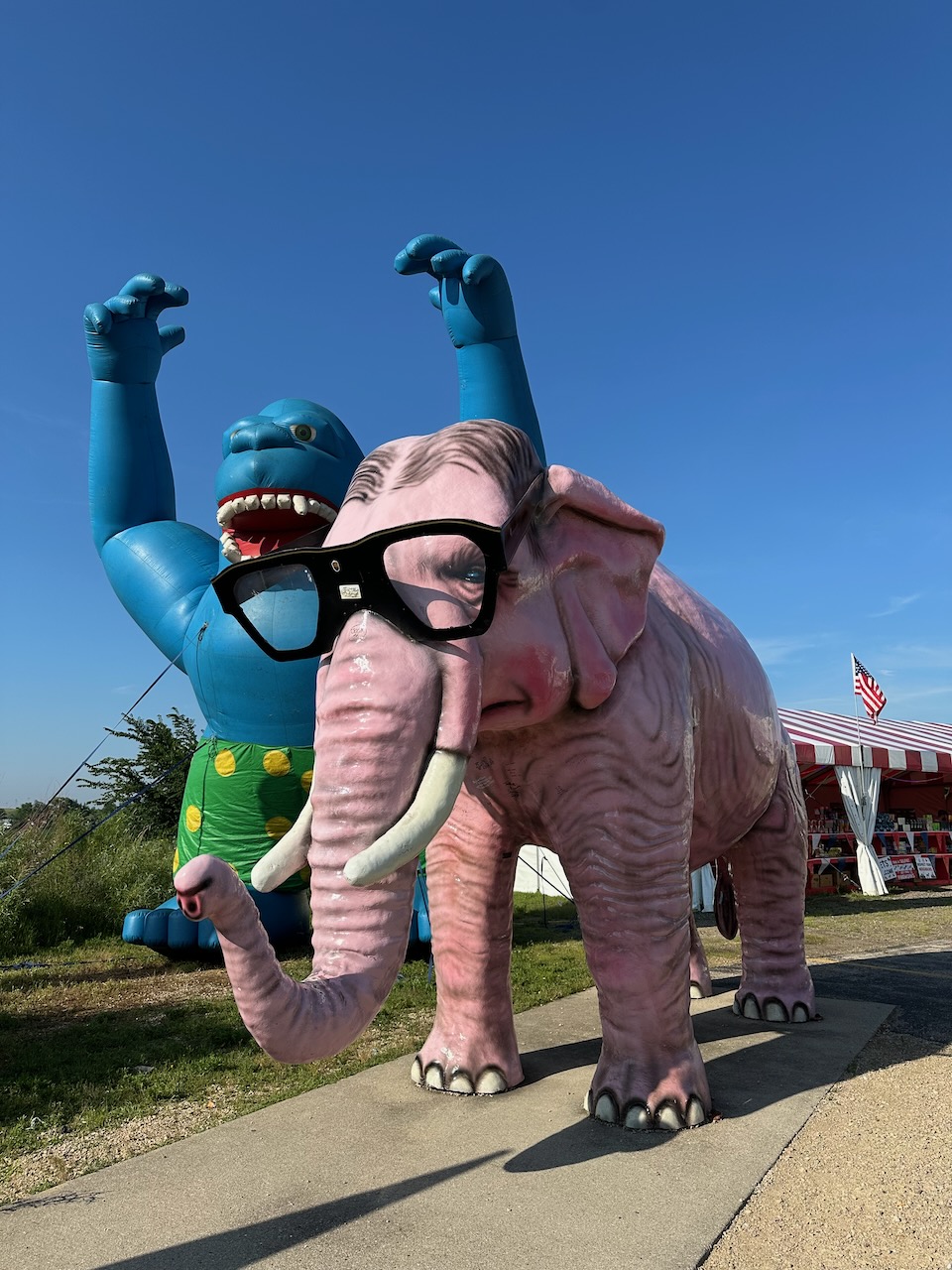 Pink elephant statue, with inflatable gorilla behind it.