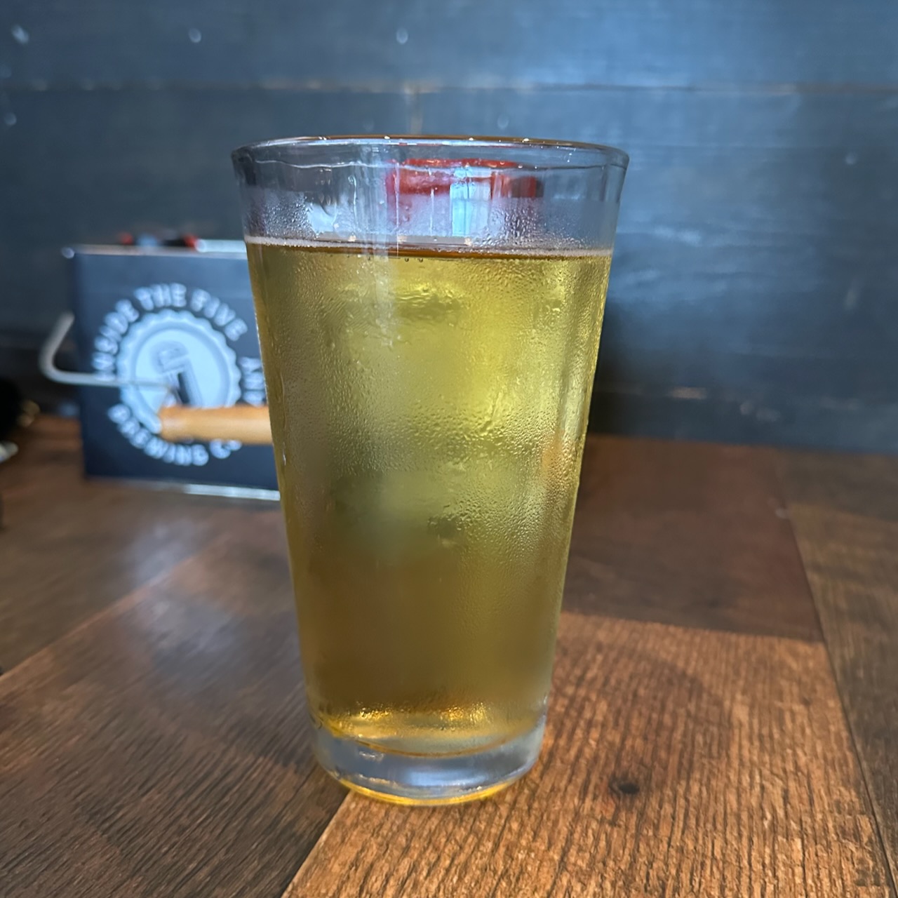 Glass of lager on wooden table.