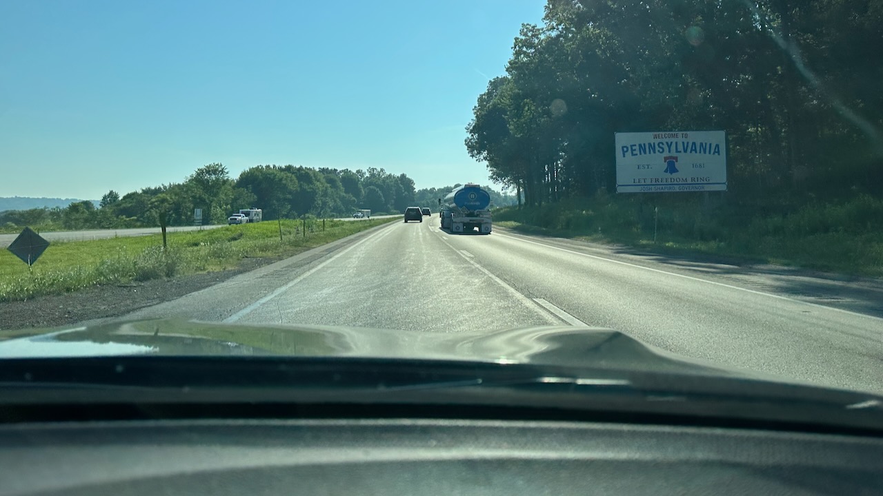 Welcome to Pennsylvania sign alongside highway.