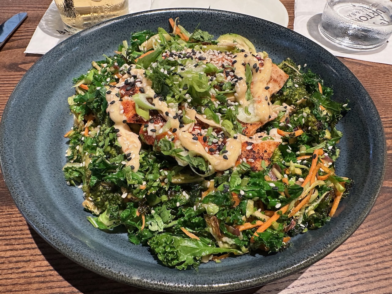 General Tso bowl in gray bowl on wooden table.