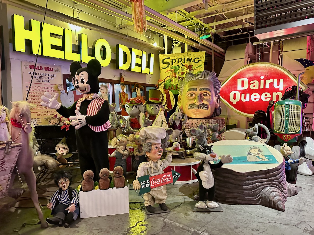 Various toys, dolls, and neon signs for restaurants including HELLO DELI and DAIRY QUEEN