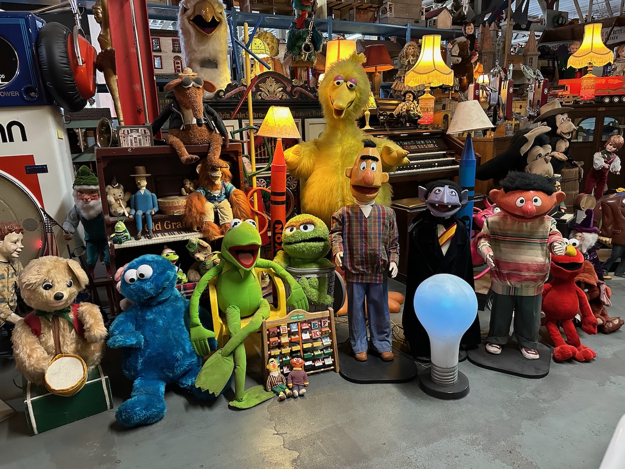 Sesame Street character puppets, with various items behind them.