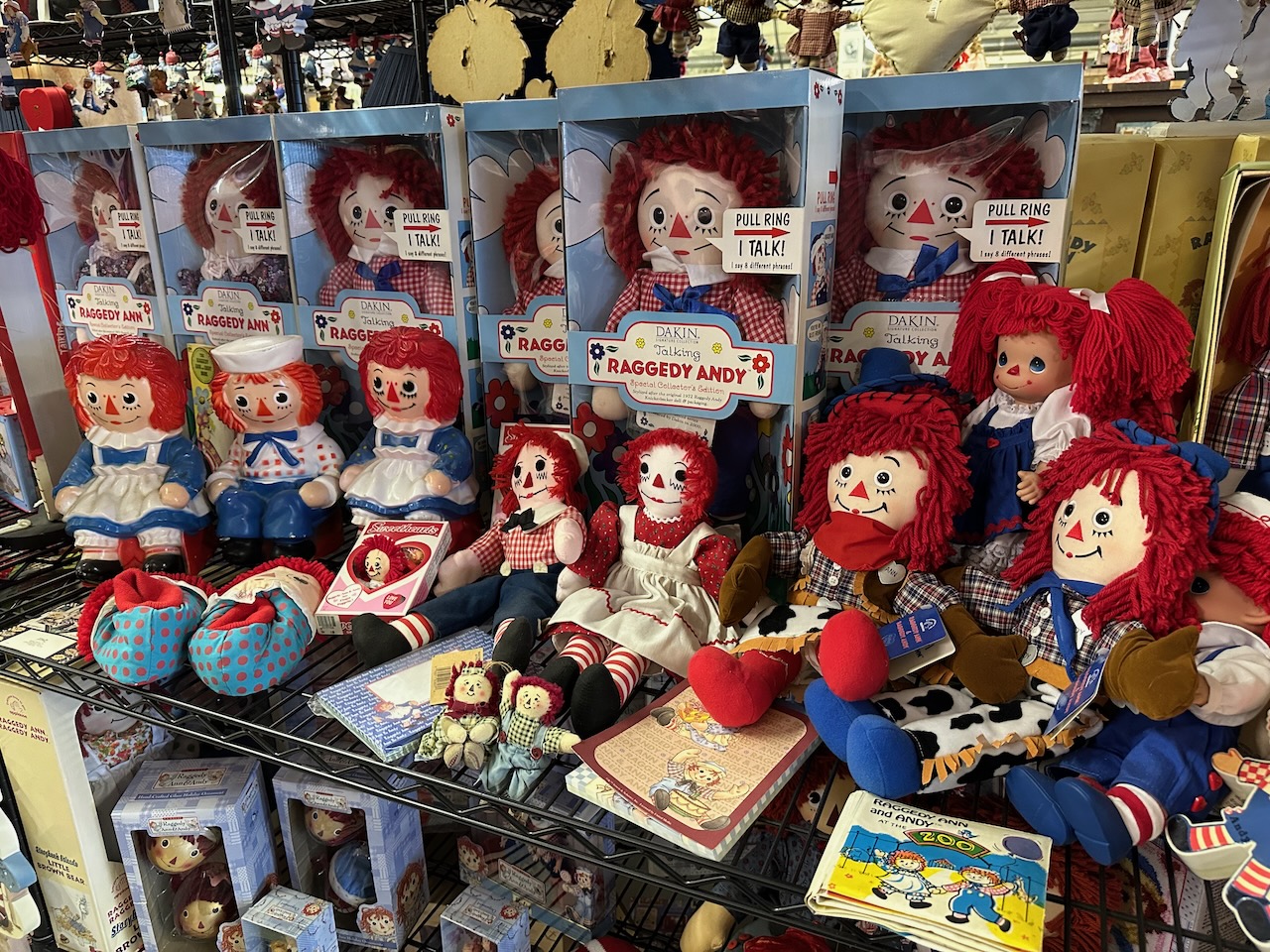 Assortment of various Raggedy Ann toys on shelves.