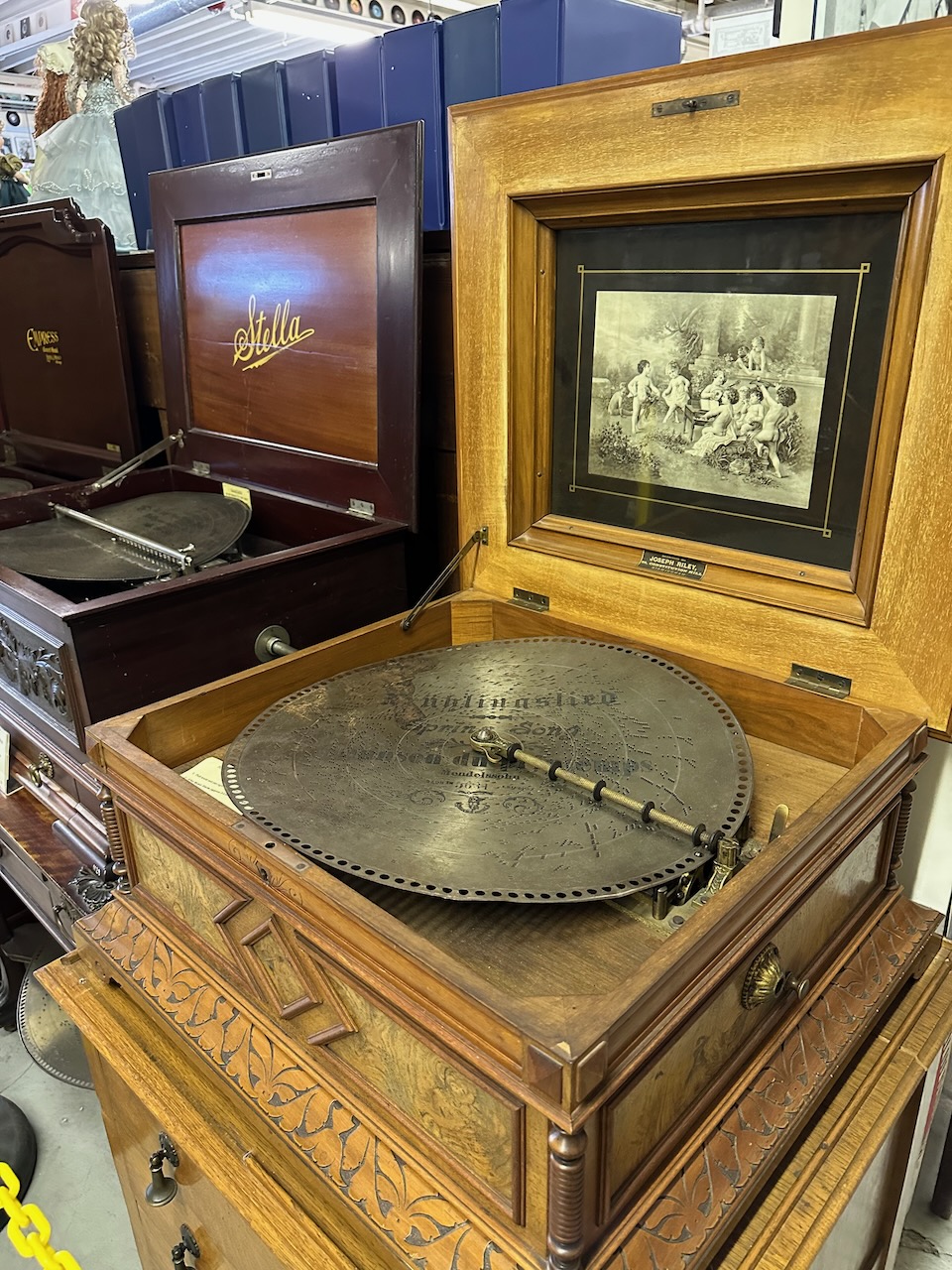 Disc music box made from wood, with metal record on turntable.