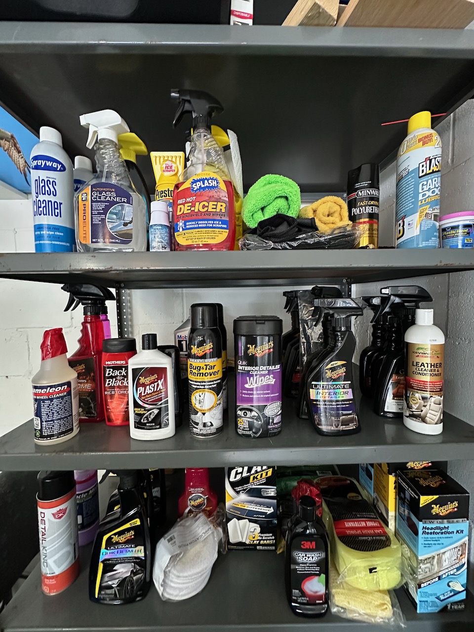 Metal shelves in garage with car care products.