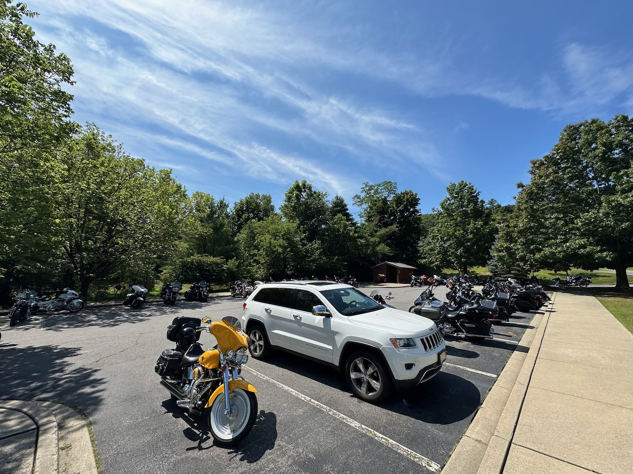 2014 Jeep Grand Cherokee in parking lot, surrounded by motorcycles.