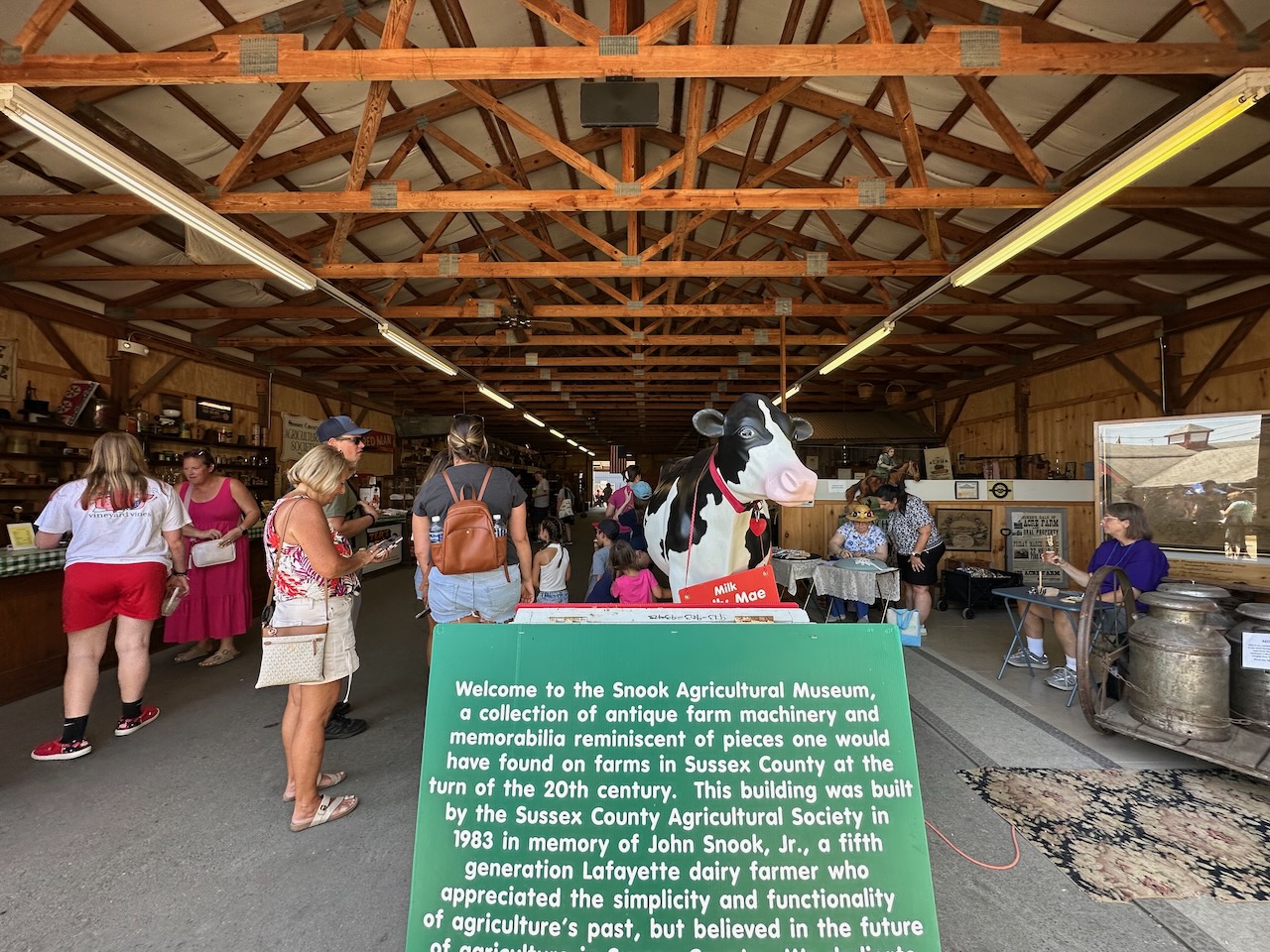 People in exhibition hall, with statue of cow in foreground.