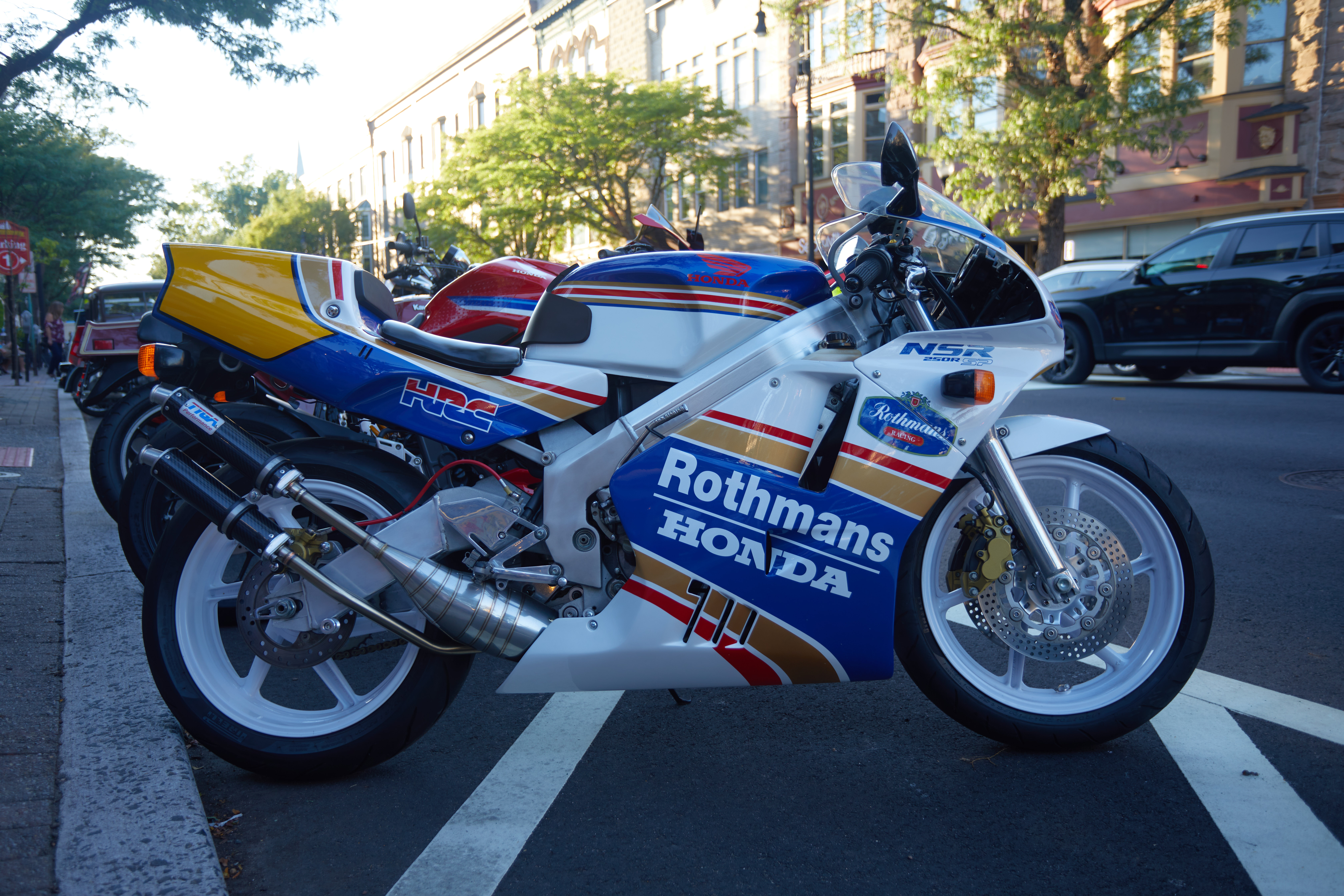 Honda racing motorcycle at front of row of motorcycles. 