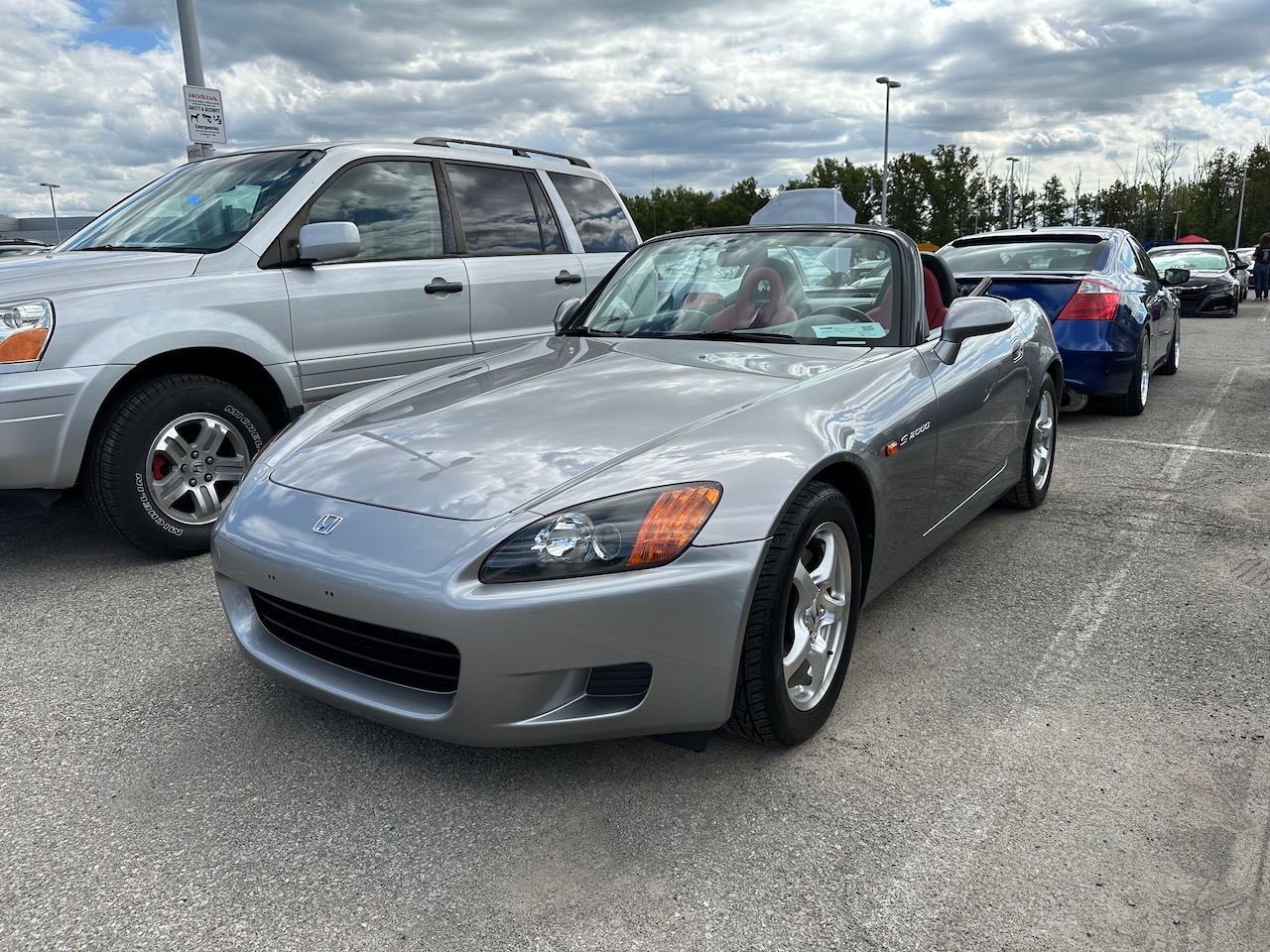 Honda S2000 in silver, with top down.