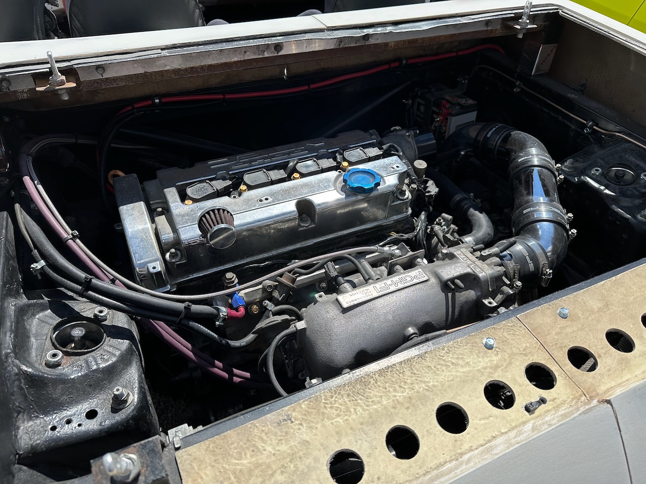 Honda Prelude engine in engine bay at rear of hot rod.