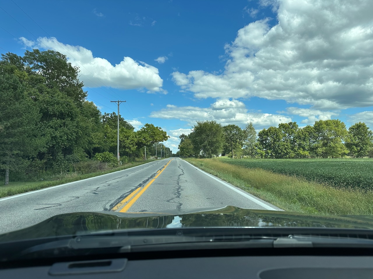 View of two-lane country road with trees on either side of road.