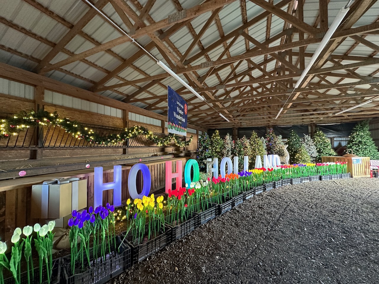 Interior of building filled with tulips, with block letters that read HO HO HOLLAND