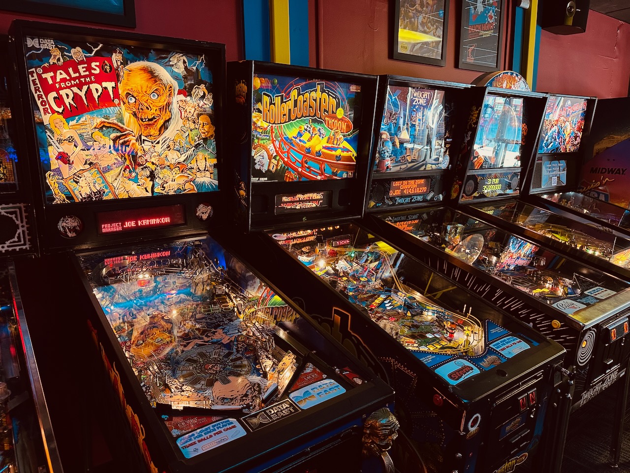 Row of pinball machines in arcade.