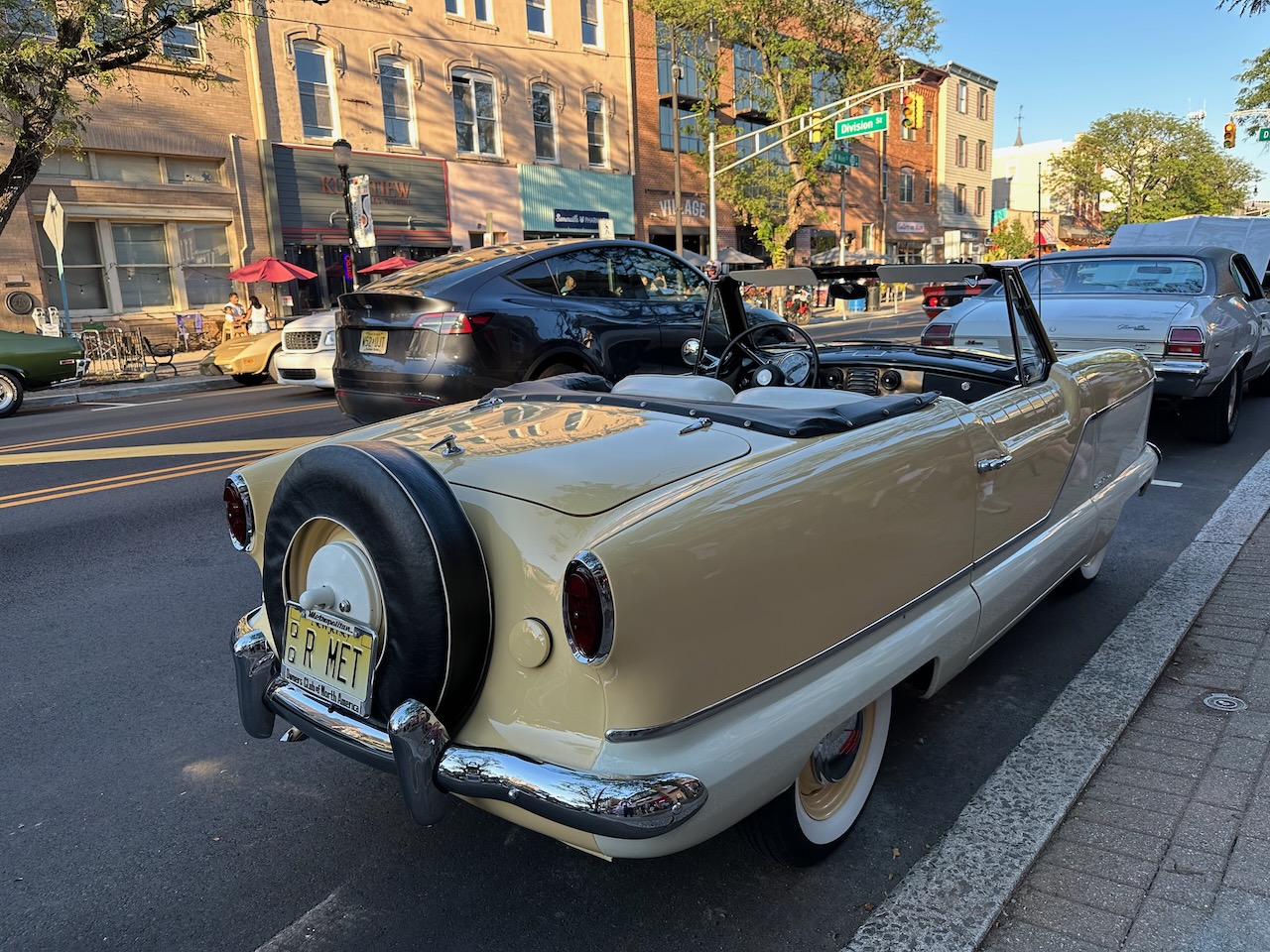 Tan Nash Metropolitan convertible parked along curb. 
