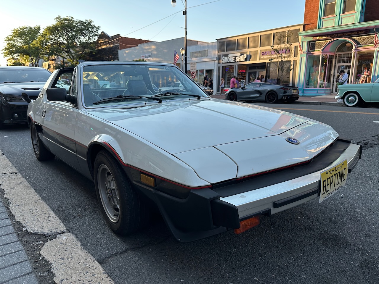 White Bertone X1/9 parked beside curb. 